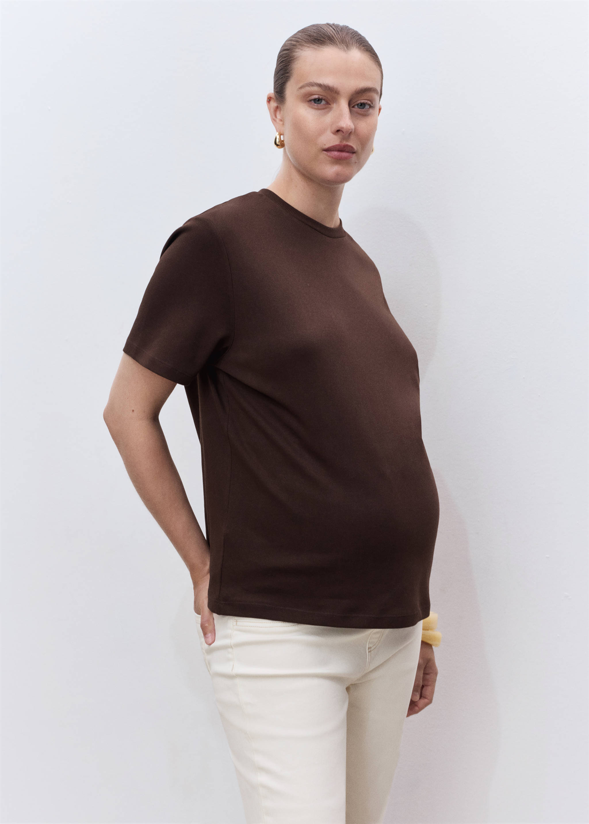 White jeans styled with a brown short-sleeved t-shirt.