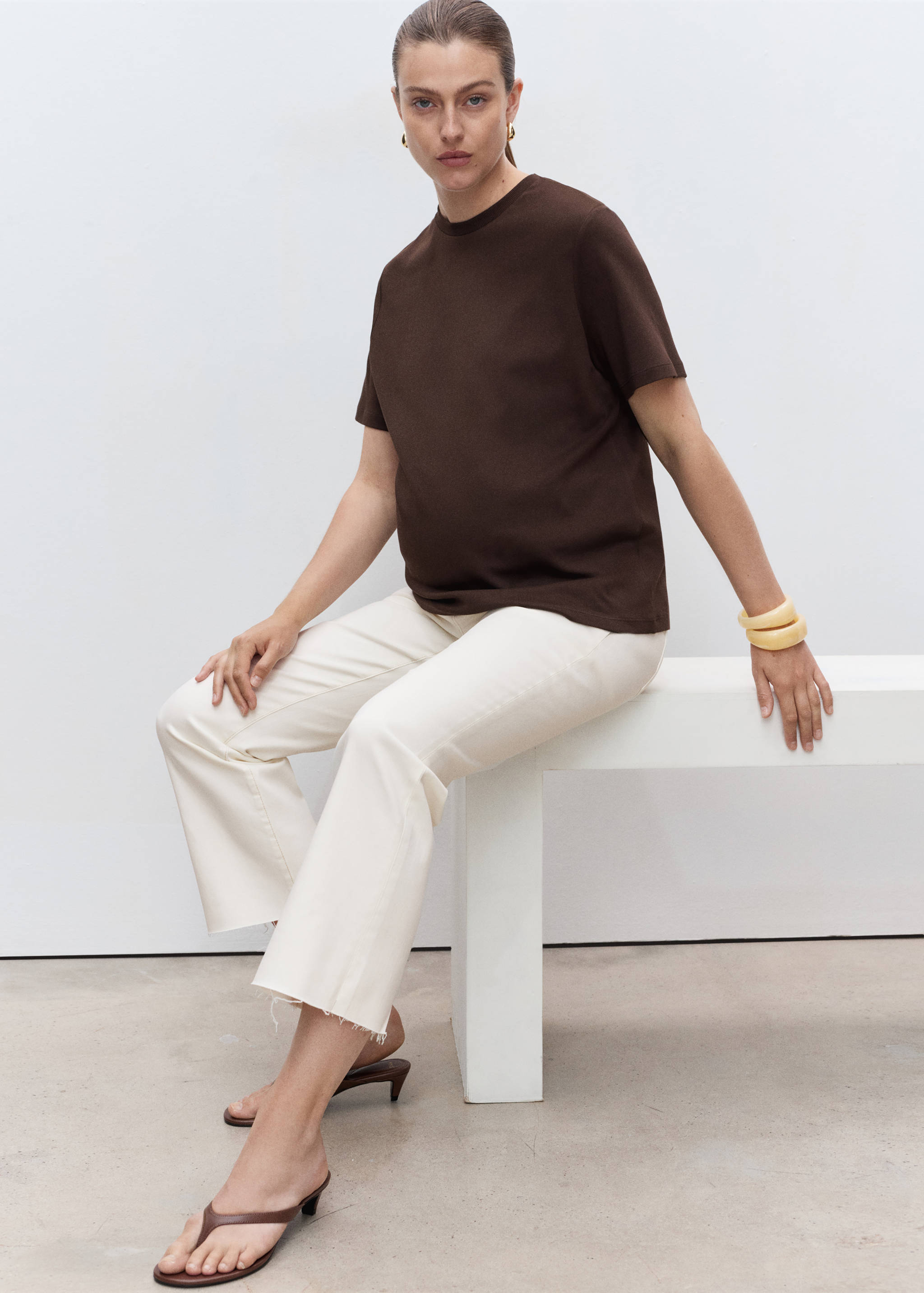 White cropped jeans with raw hems, worn with a brown t-shirt and dark brown kitten heels.