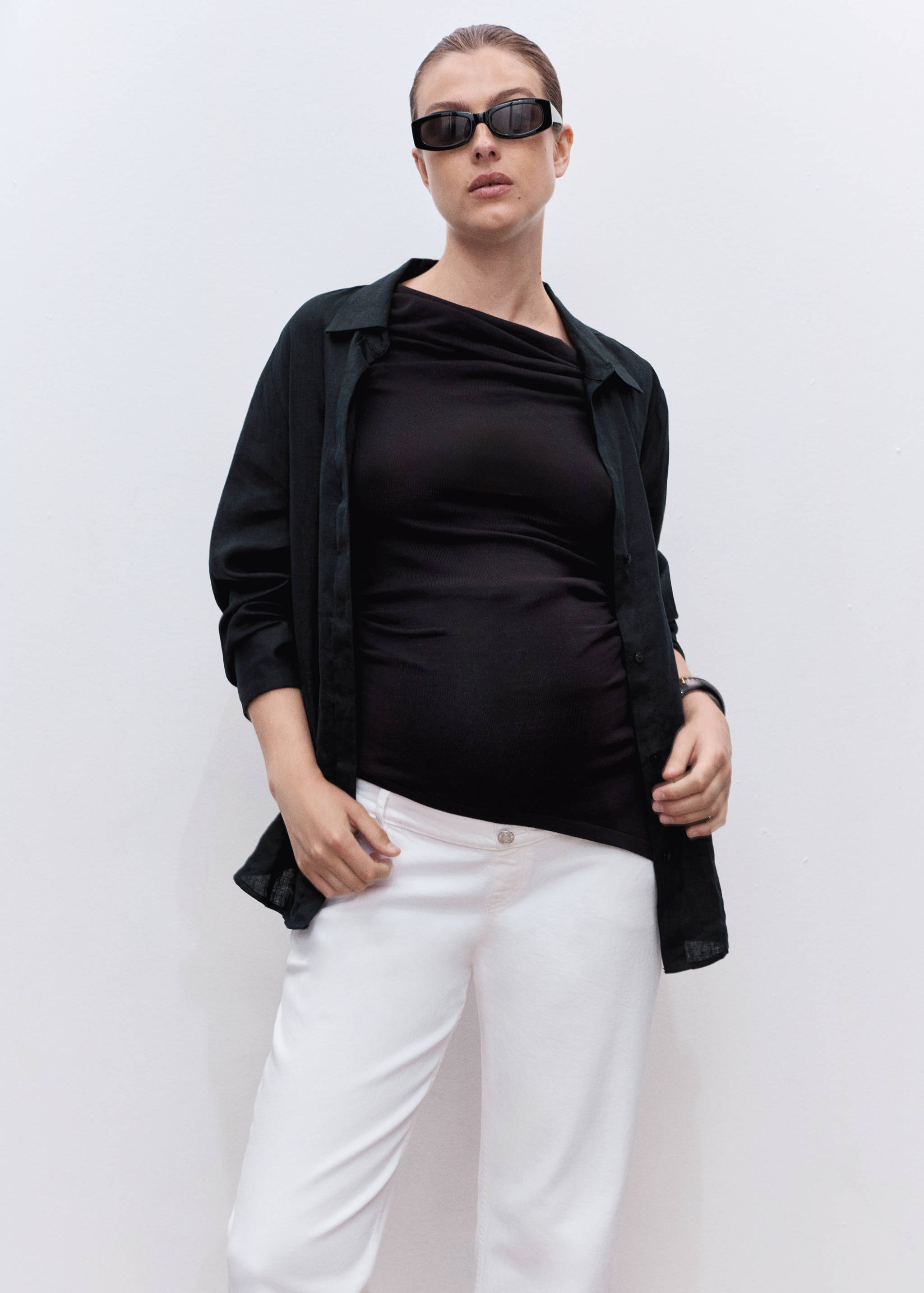 White denim trousers worn with black top and shirt.
