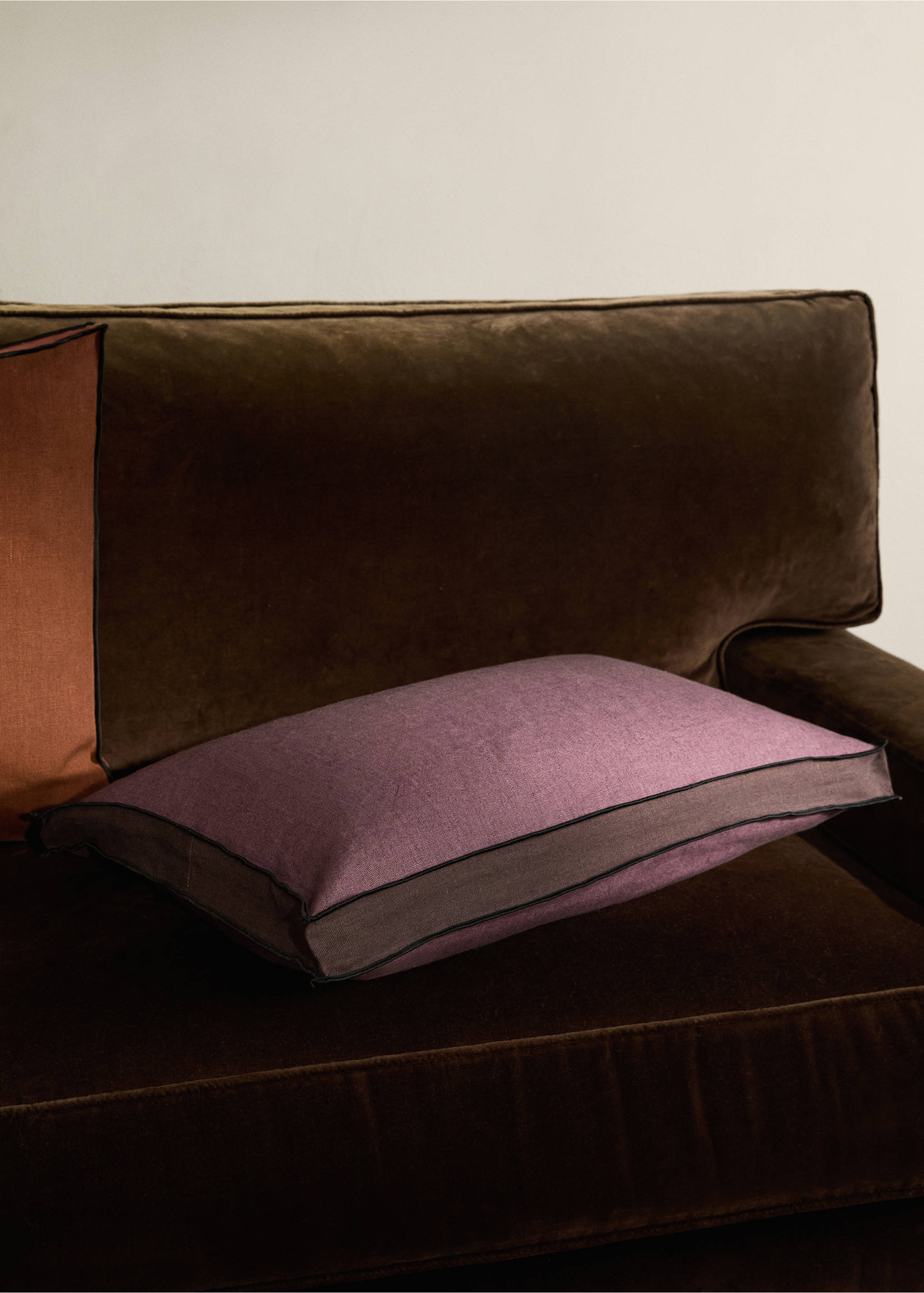 Purple and brown rectangular cushion cover with black piped trim on a sofa., Plum. Ref: 17003318-00.