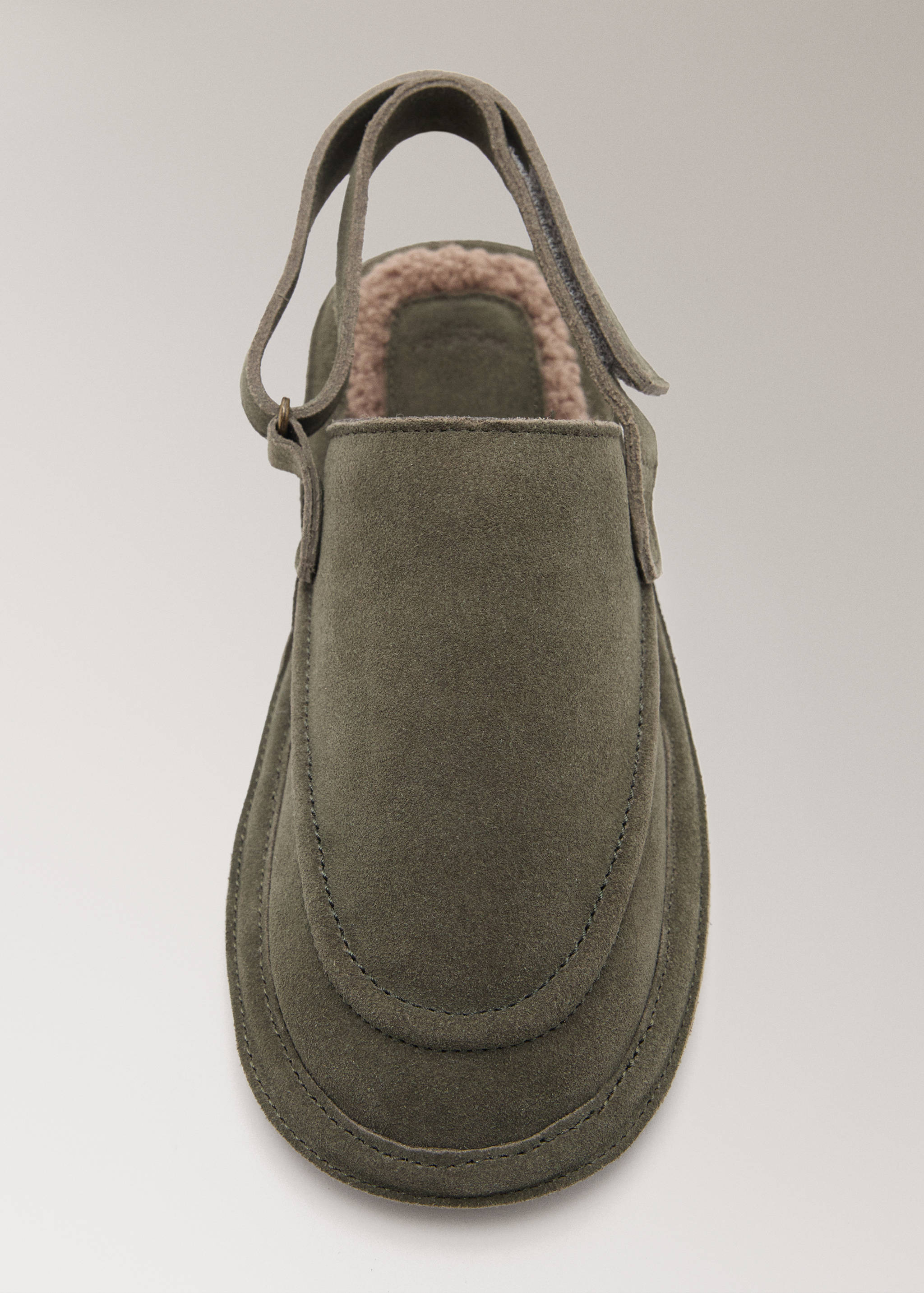 Olive green slippers with a slingback strap and soft lining, shown in close-up.