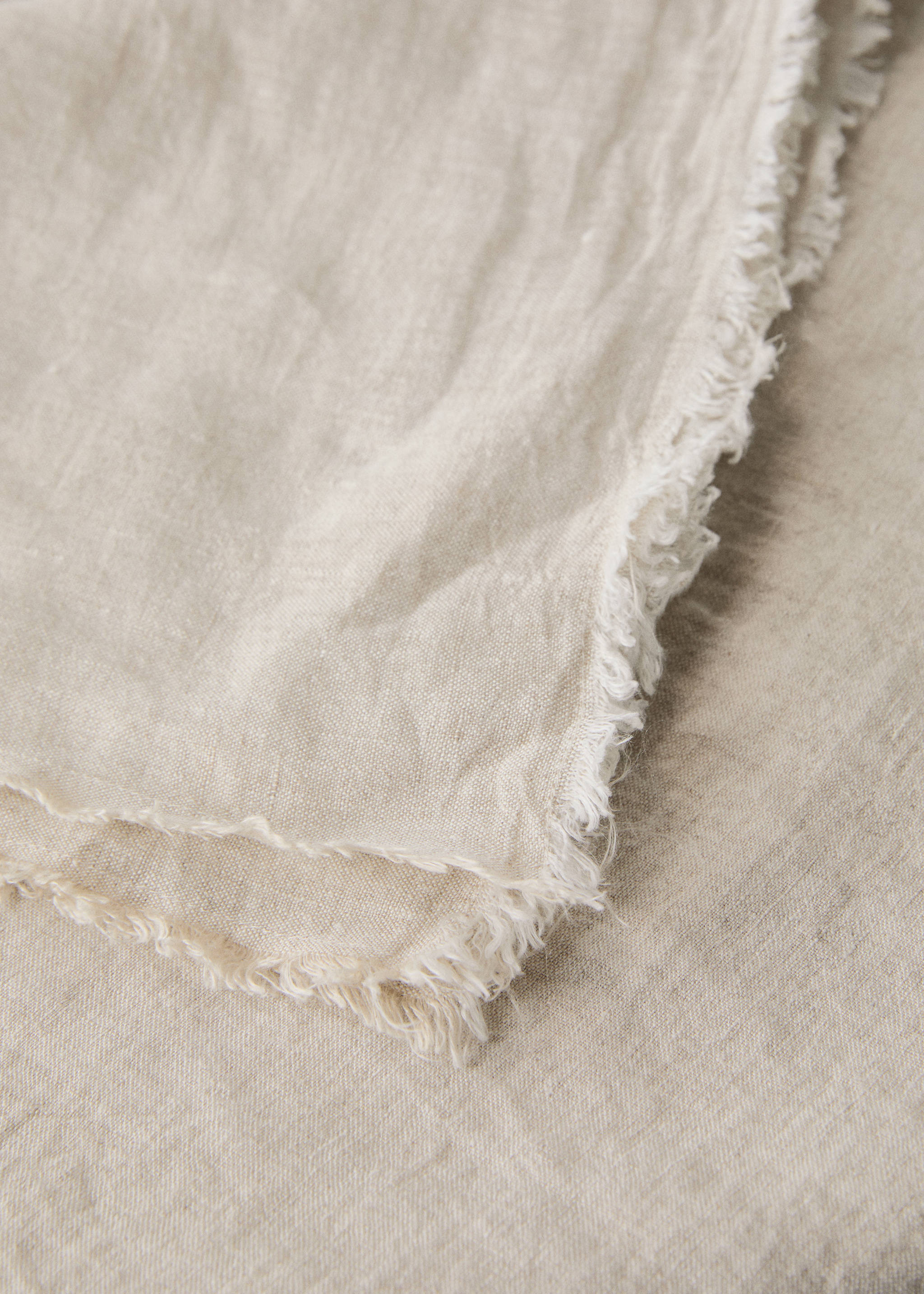 Beige tablecloth detail with frayed edges