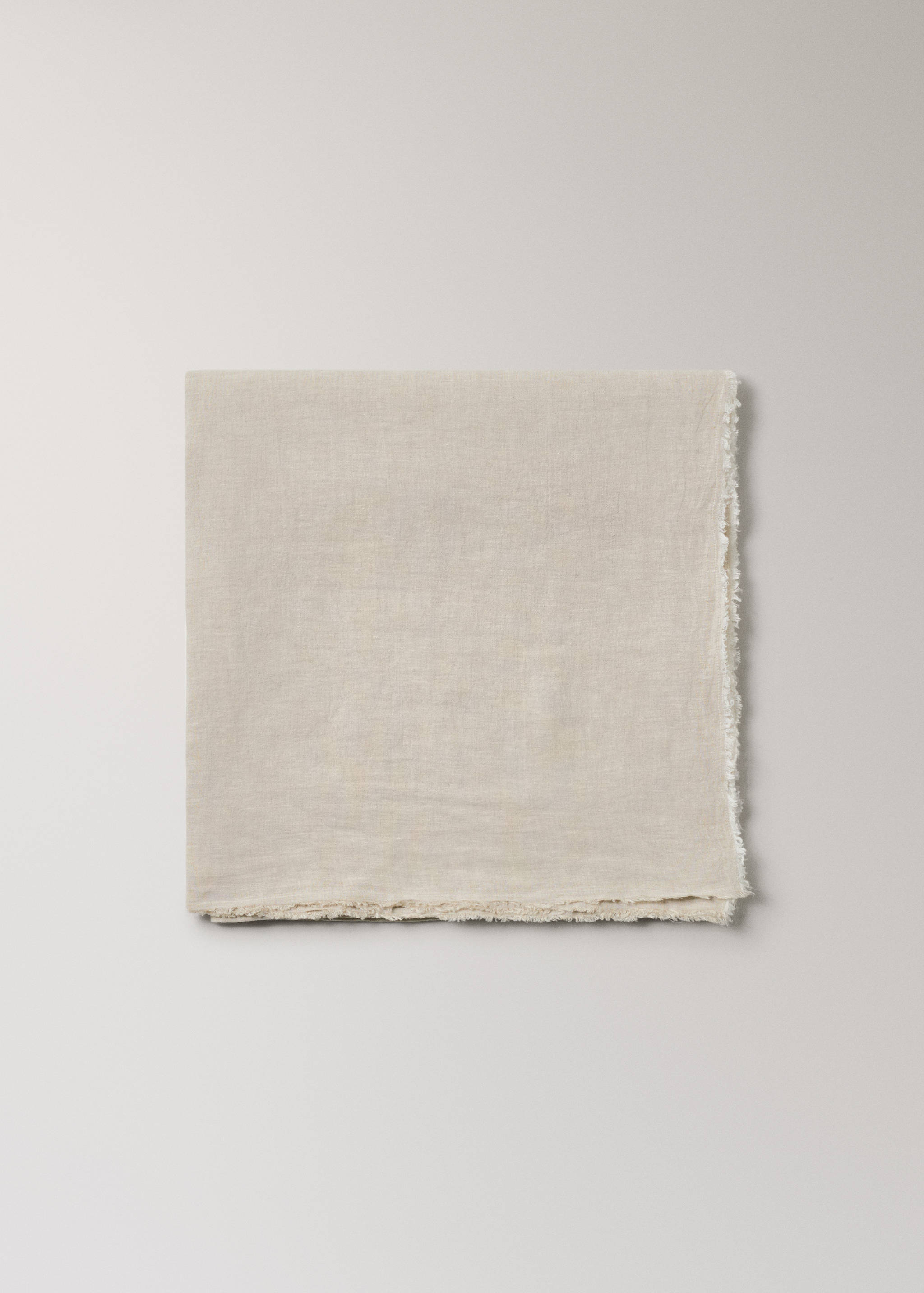 Beige tablecloth with frayed edge detail.