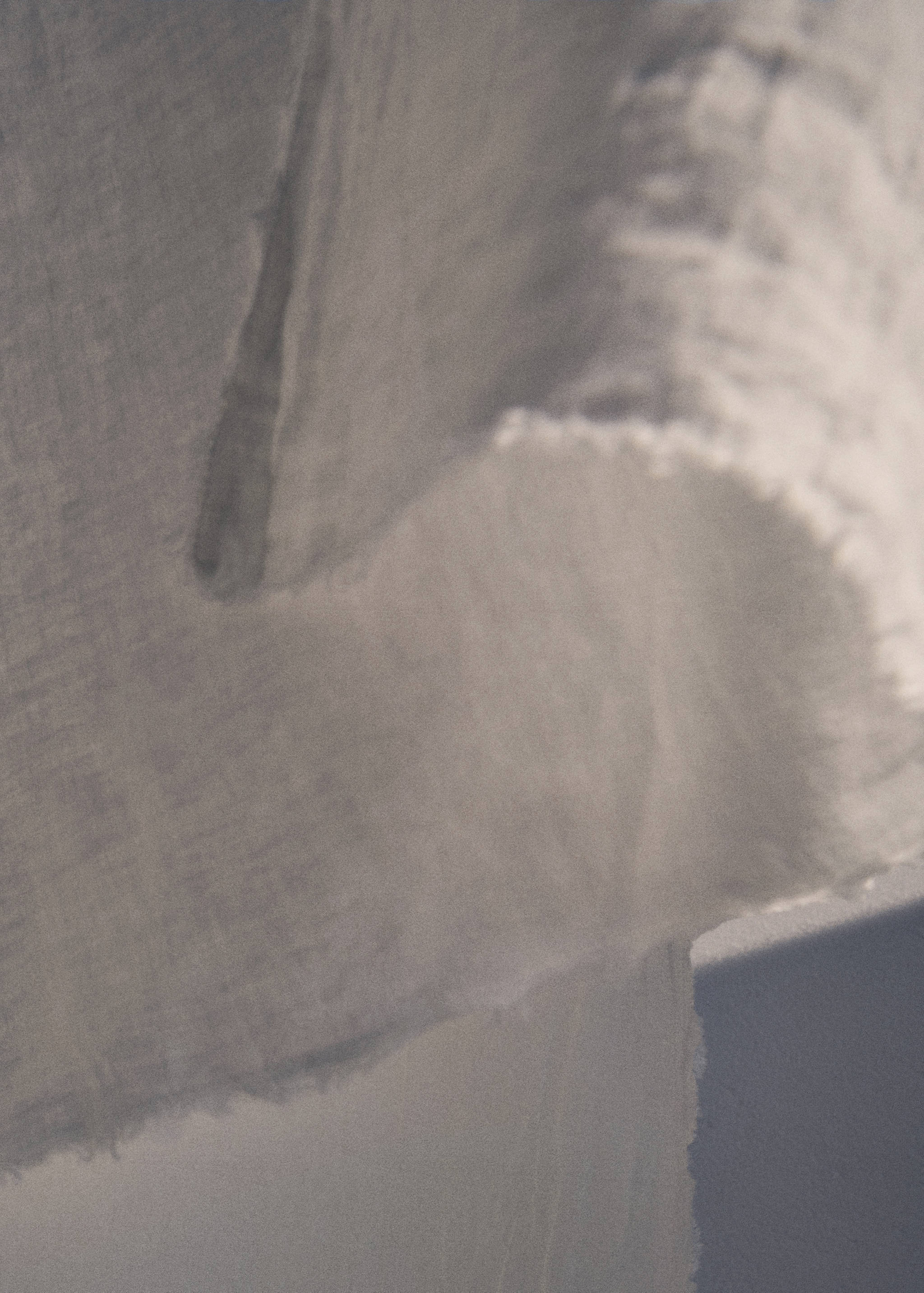 Close-up of a neutral grey-brown tablecloth with a frayed edge.