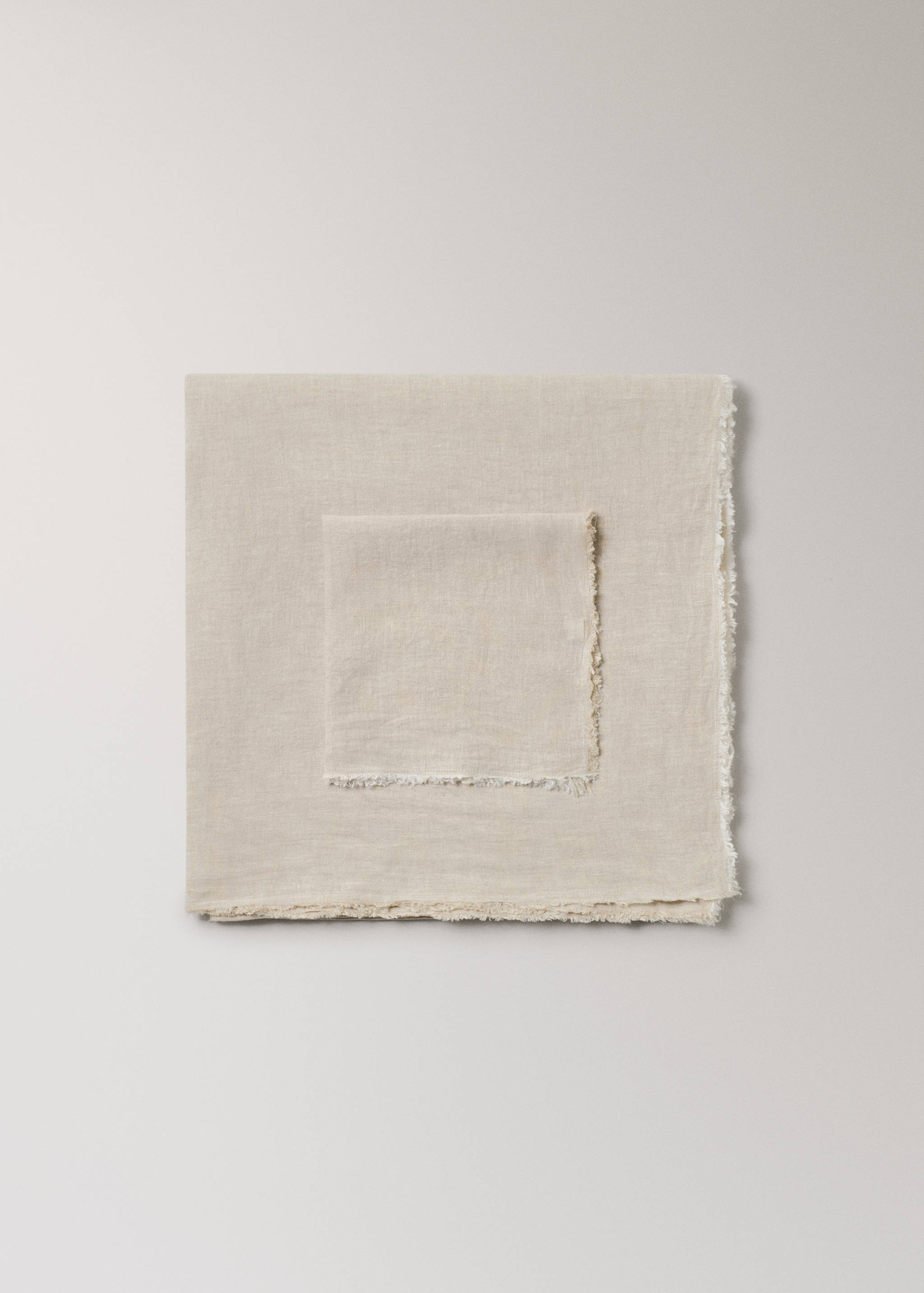 Beige linen tablecloth with fringed edges in a still life.