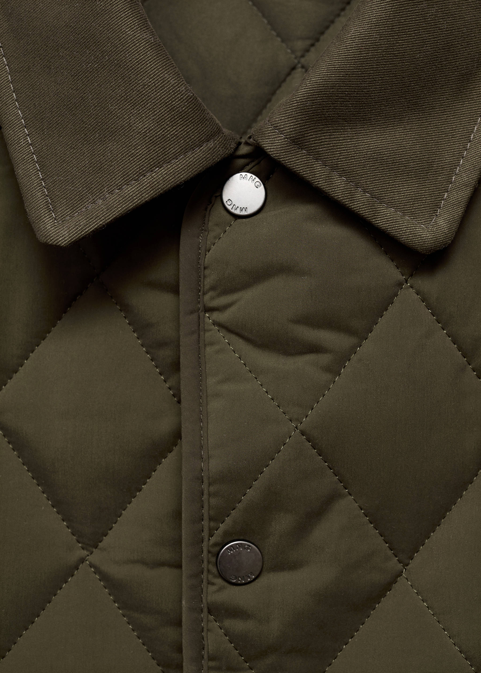 Close-up of an olive green quilted jacket collar and snap buttons.