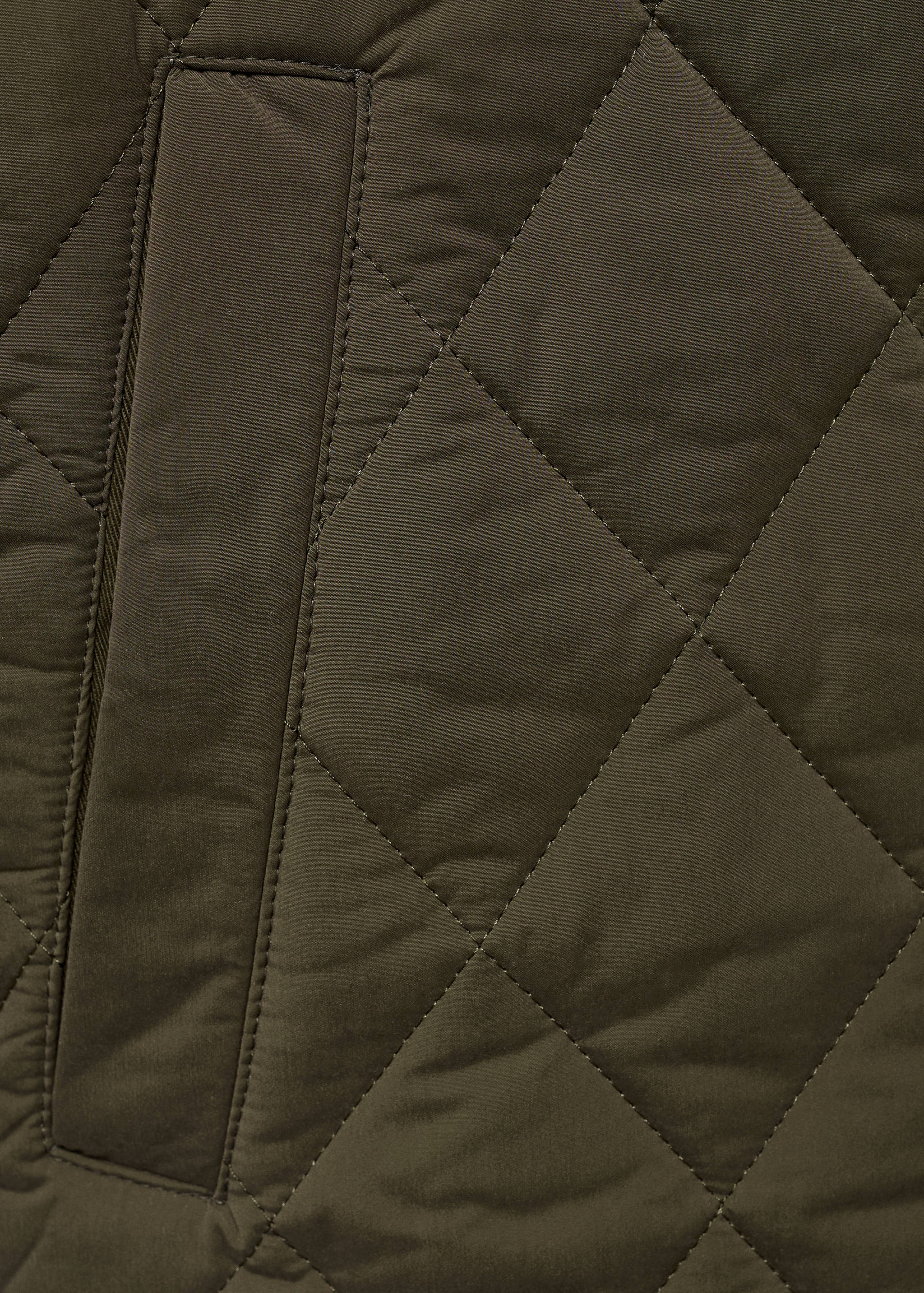 Dark green jacket fabric with diamond quilting and welt pocket.