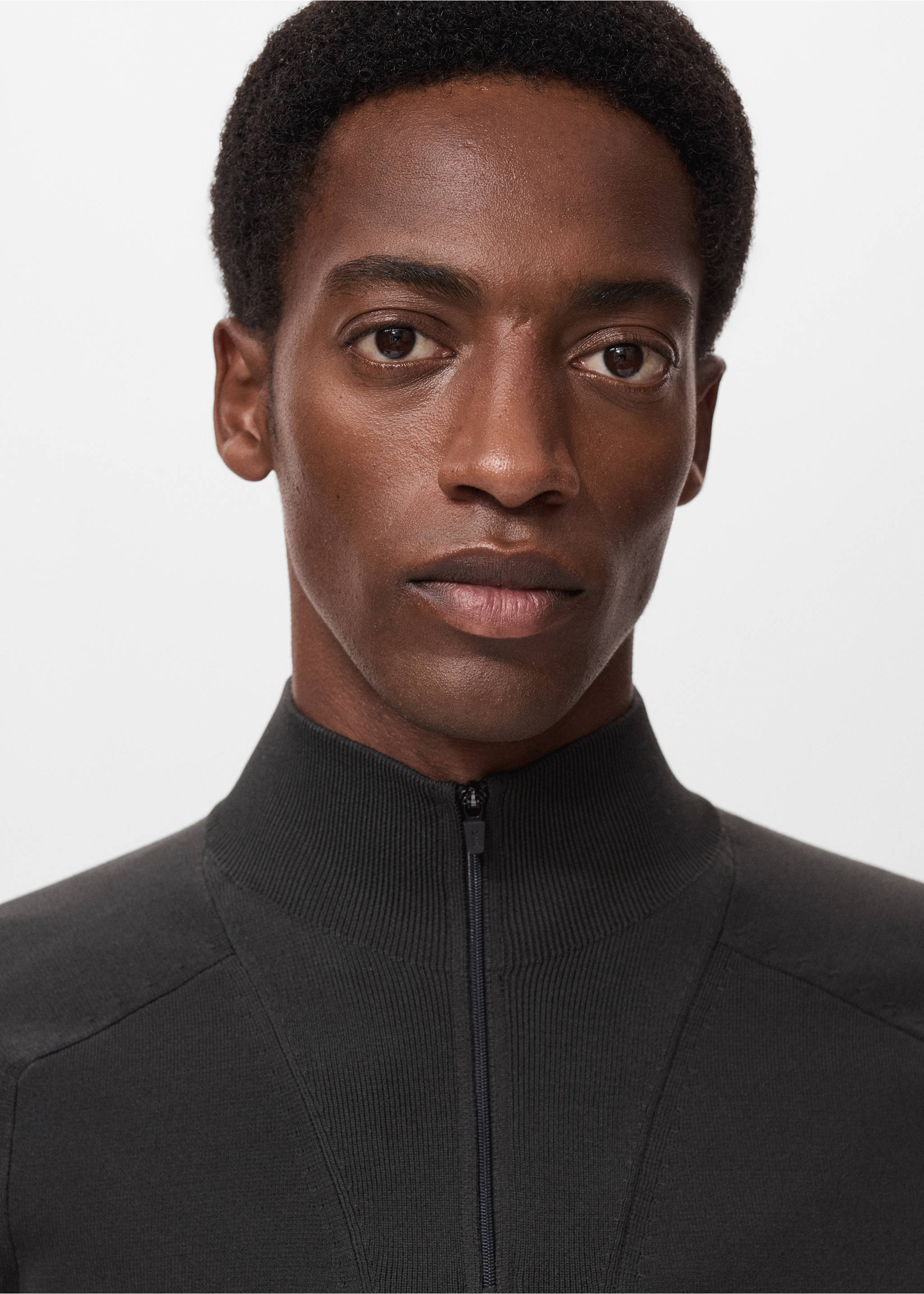 Close-up of a dark grey jersey with a high zip neck worn by a model., Dark Green. Ref: 17005979-00.