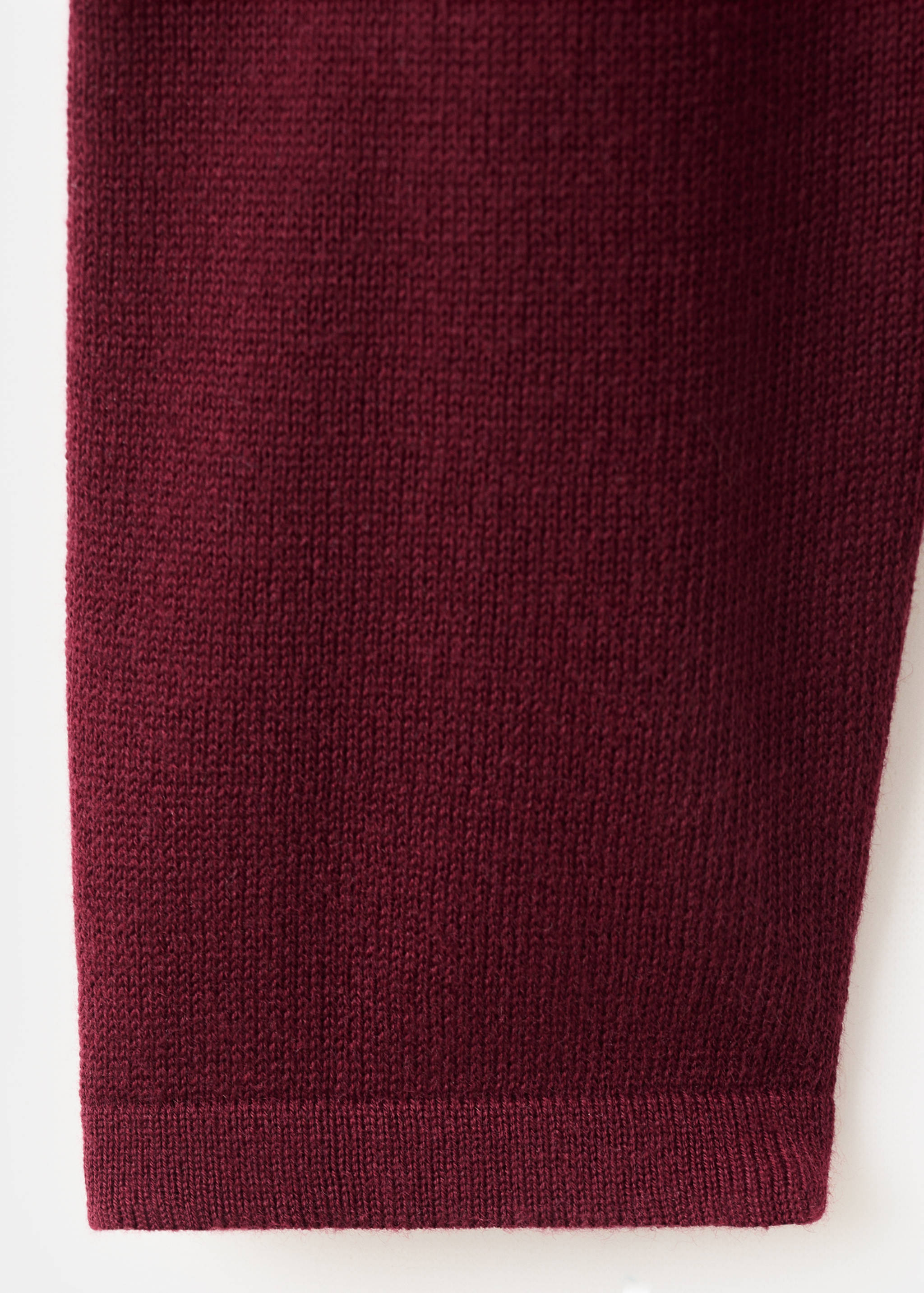 Close-up of the fine knit texture on a burgundy jersey.