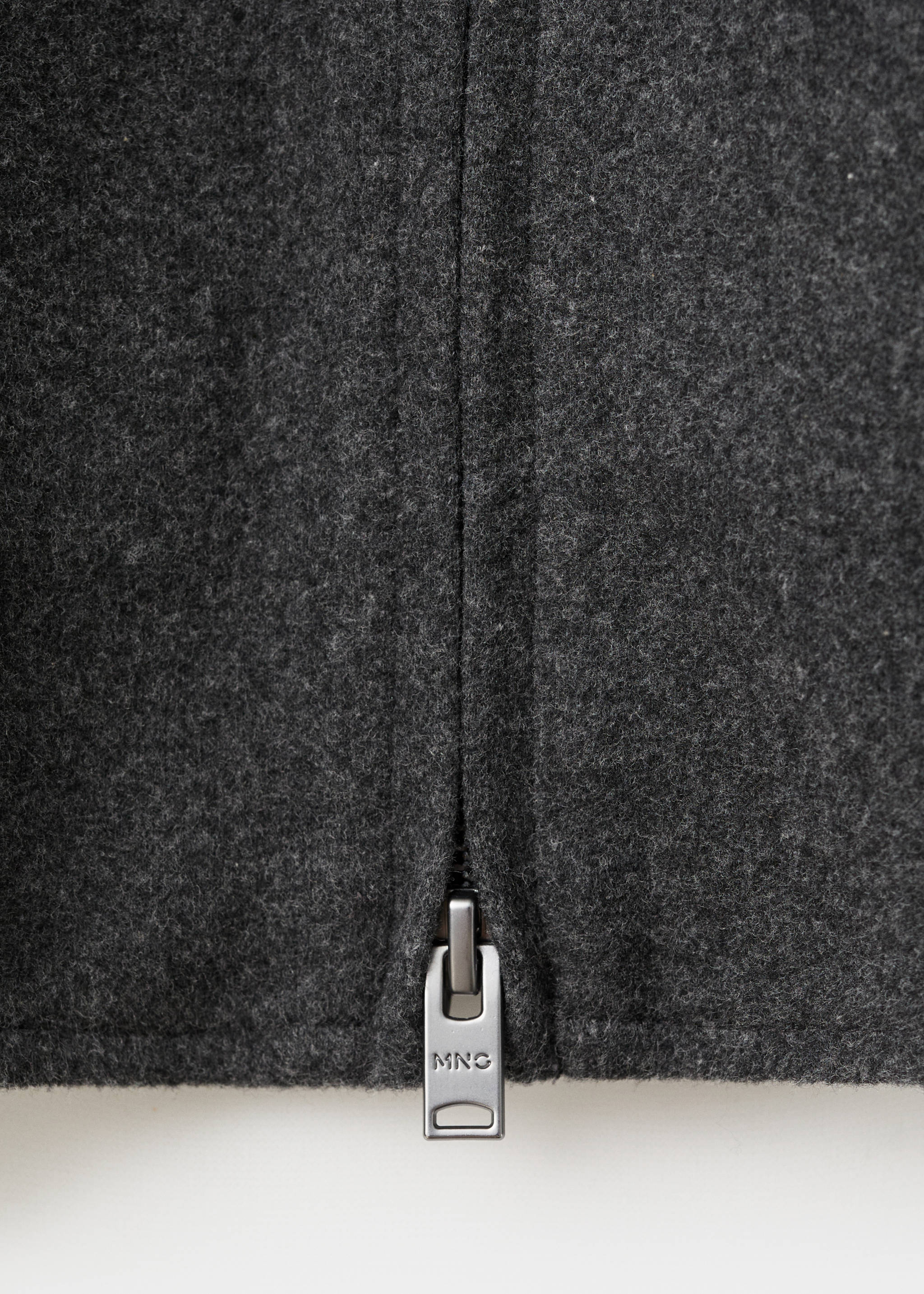 Close-up of a dark grey sweatshirt zip detail.