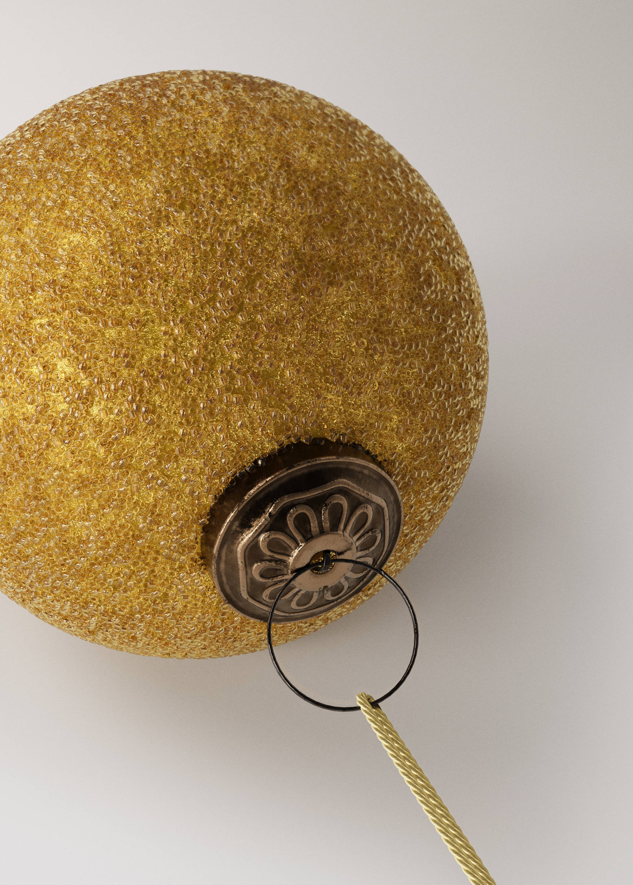 Gold beaded Christmas ornament with an ornate metal hanging cap.