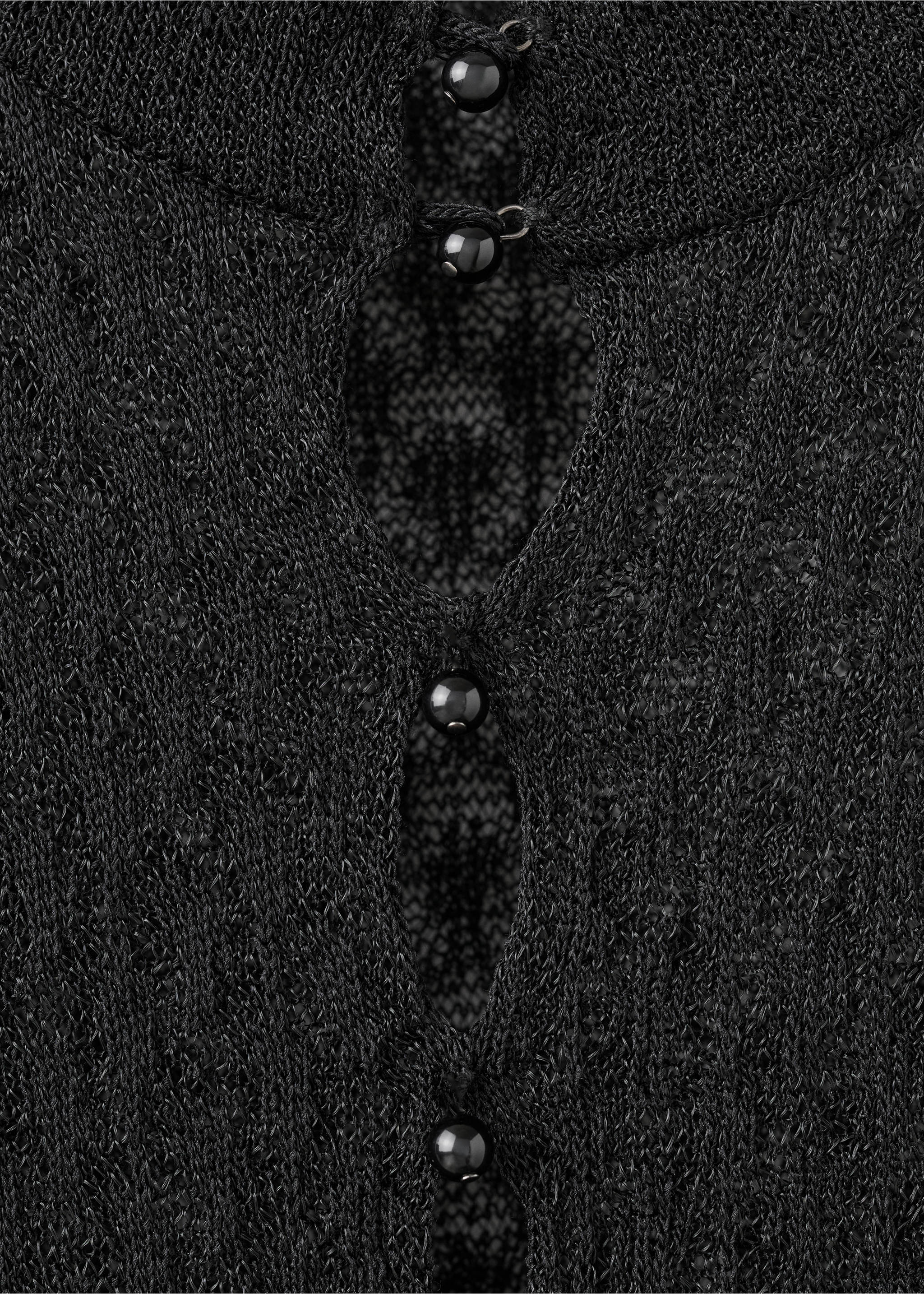 Black knit jersey fabric detail showing round buttons and keyholes., Black. Ref: 17009133-00.