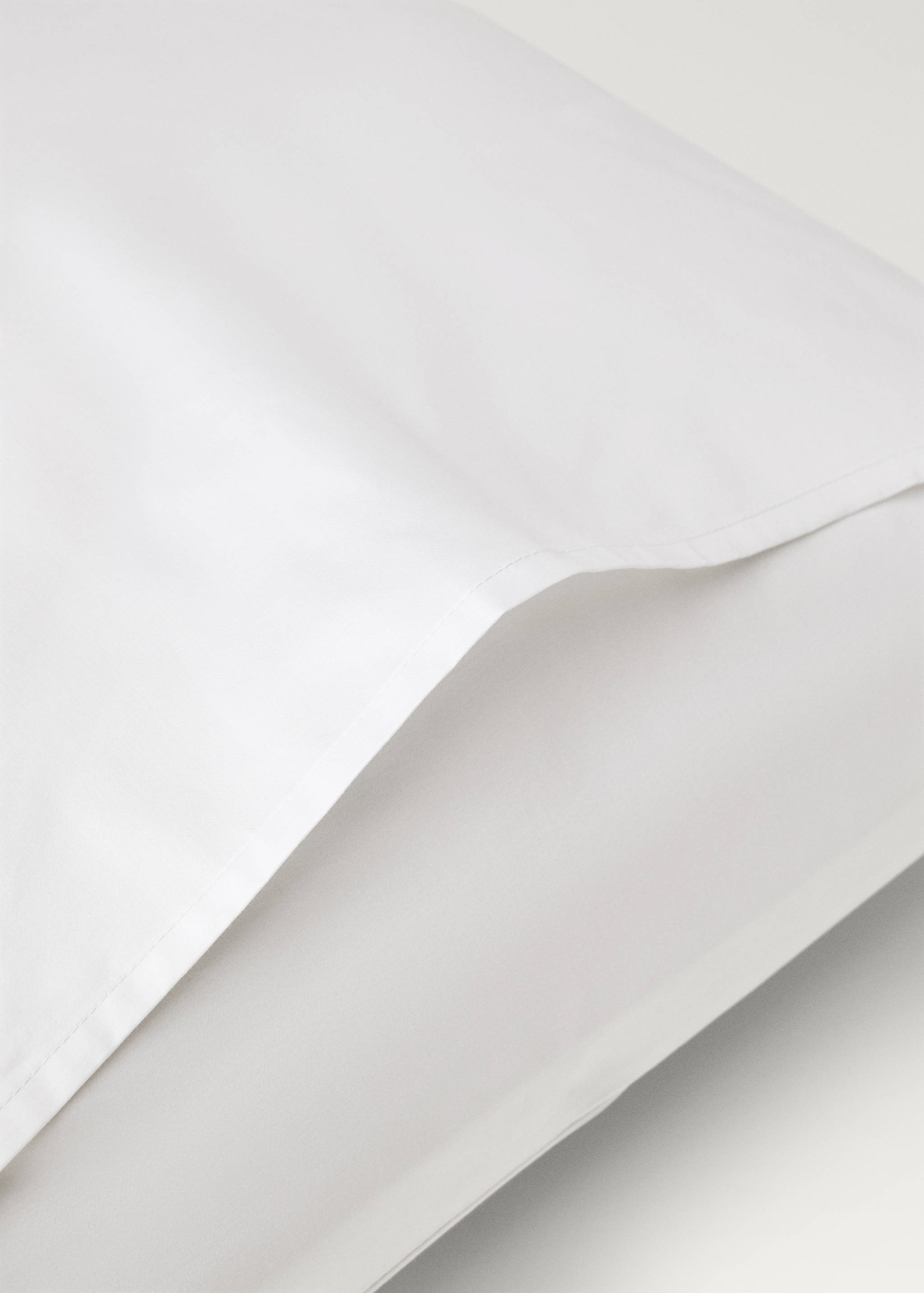 Close-up of a white pillowcase fabric detail.