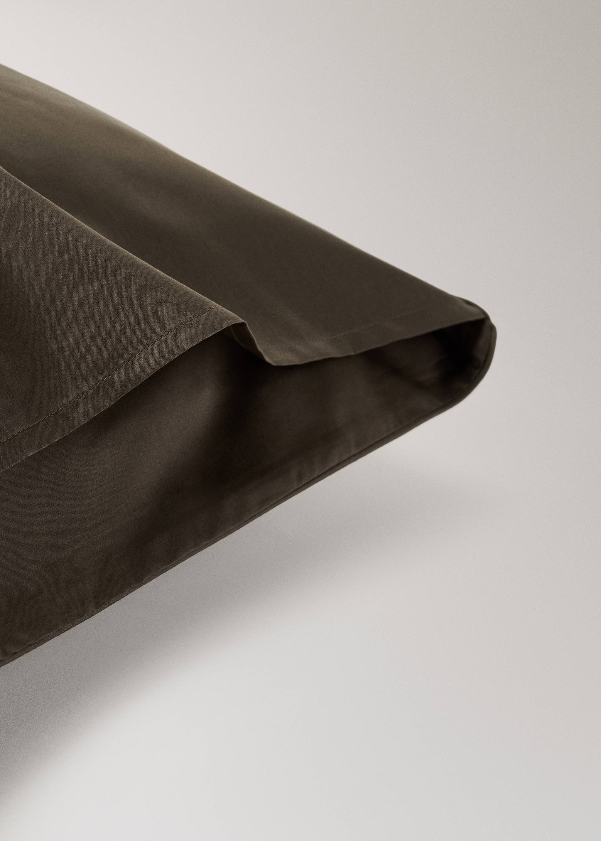 Dark khaki green pillowcase detail showing smooth fabric and neat seam stitching.