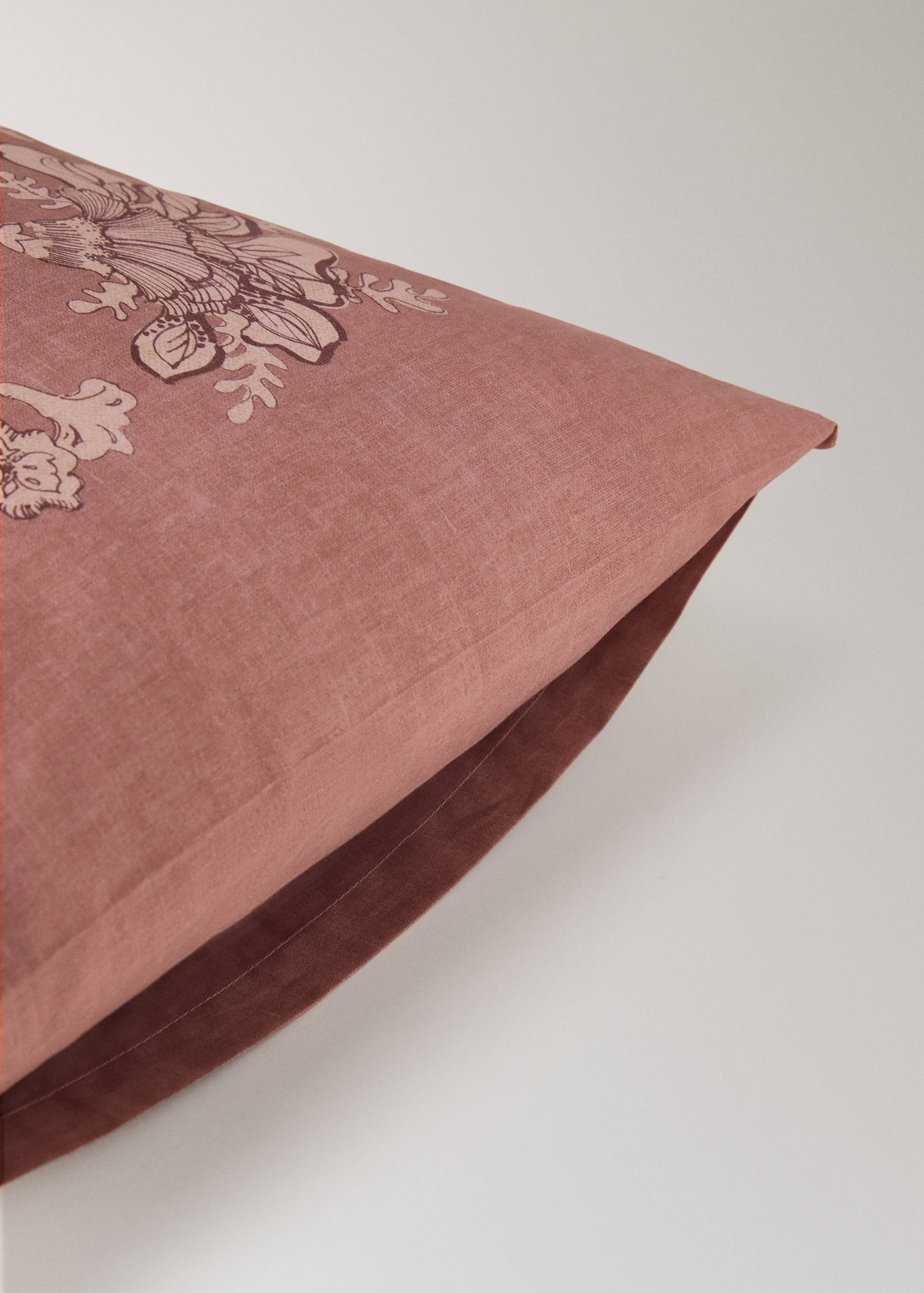 Pinkish-mauve pillowcase detail with a floral print.
