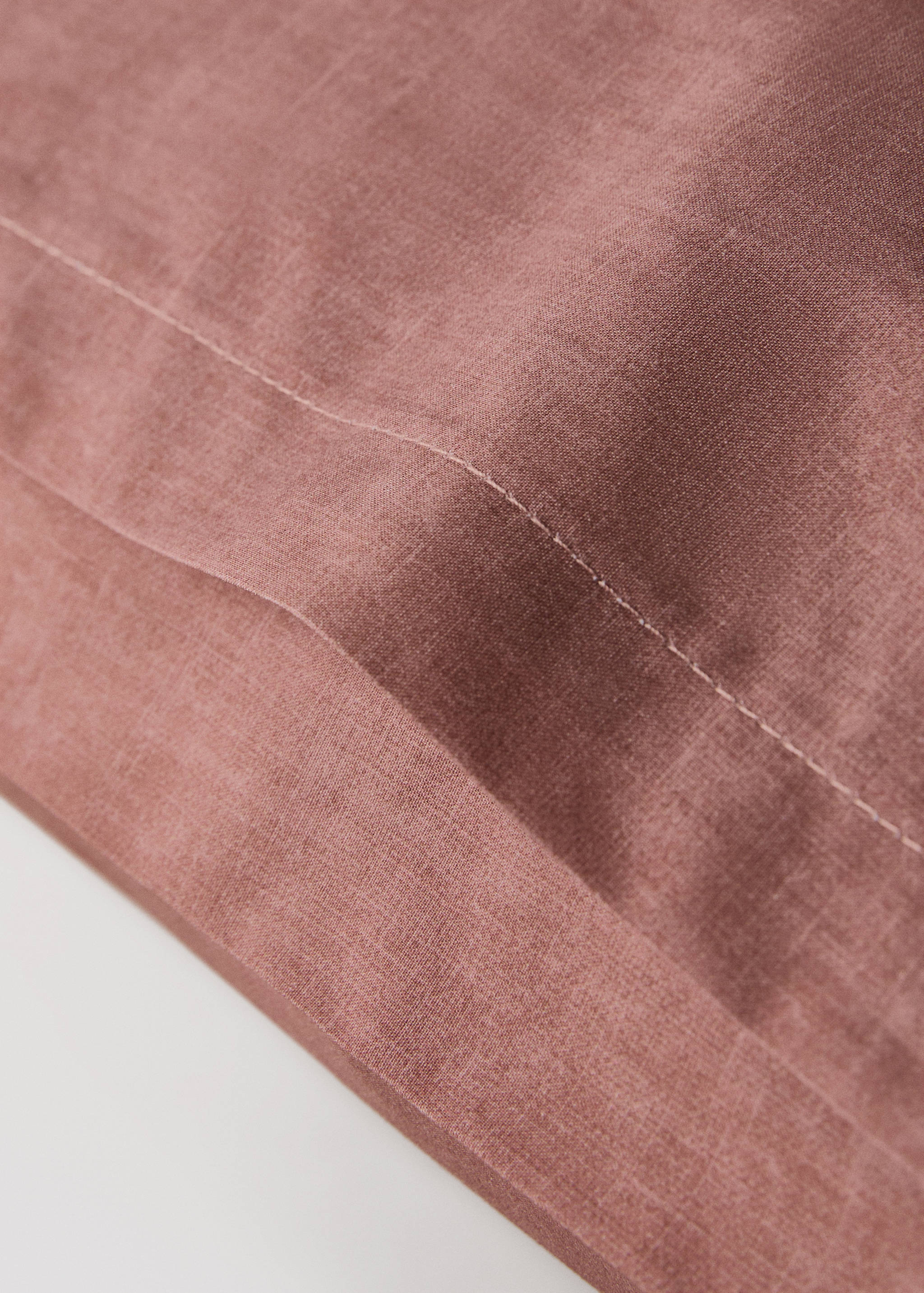Close-up of a mauve pillowcase showing fabric texture and stitched hem detail.