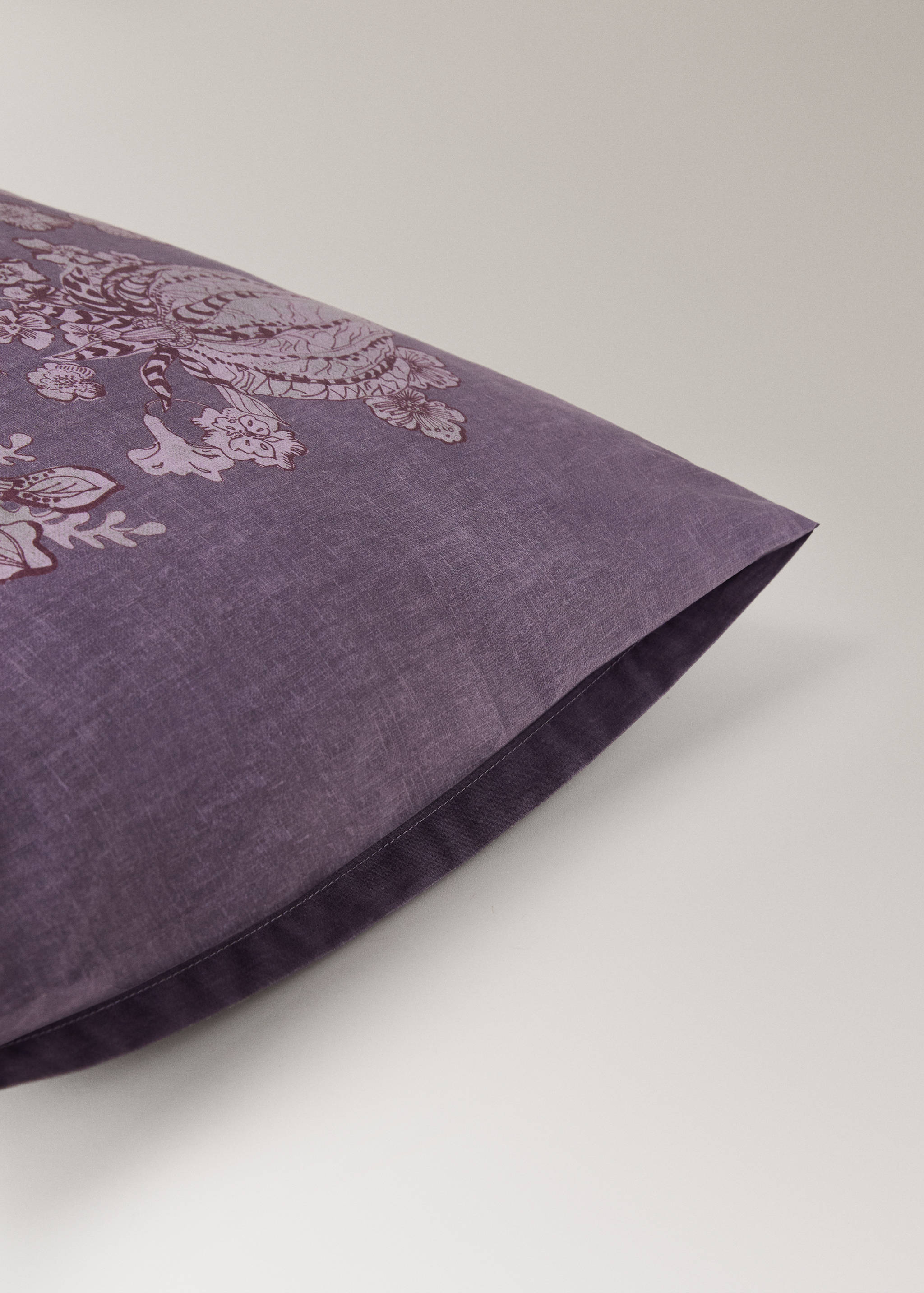 Purple pillowcase with a dark floral and animal print.
