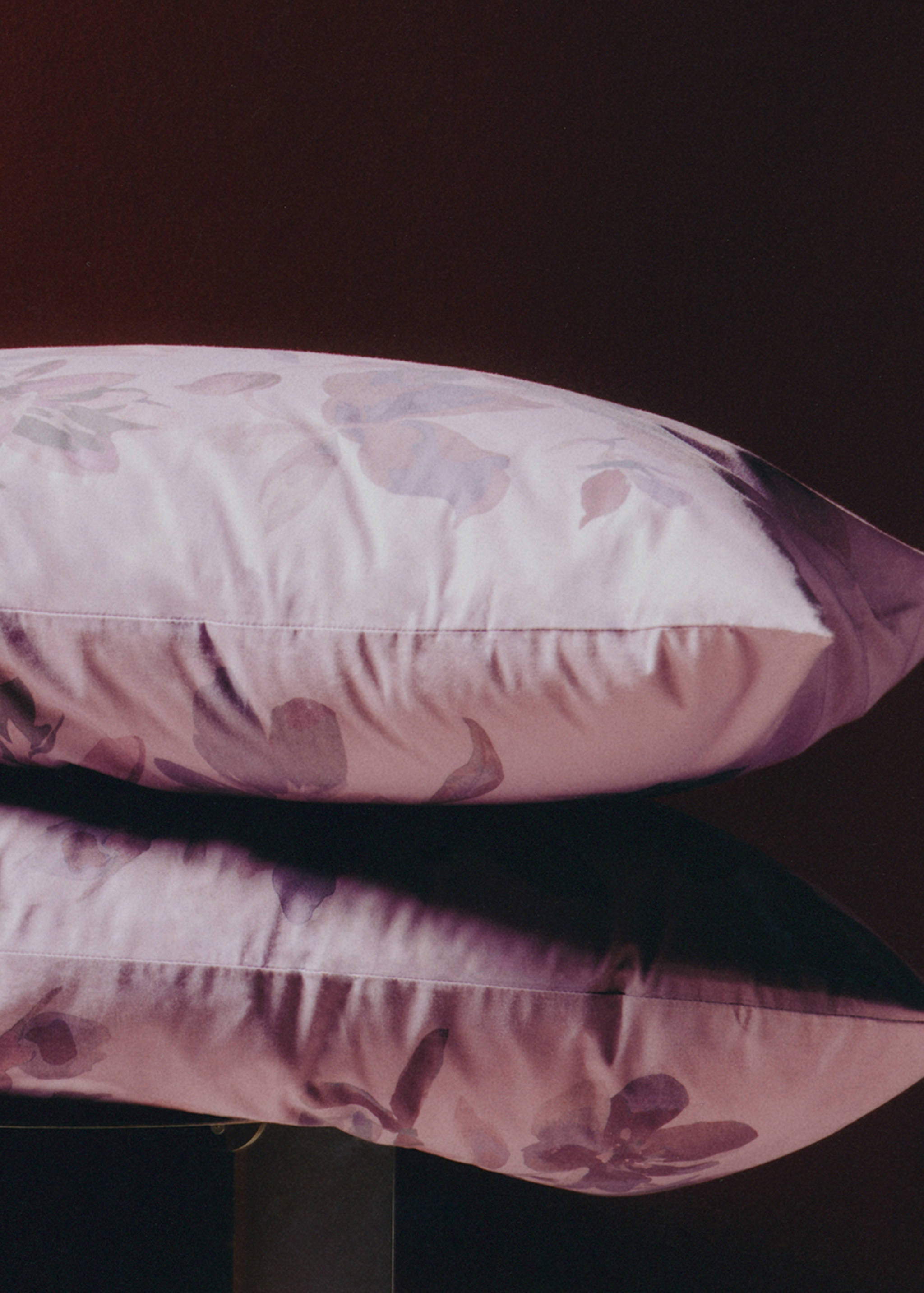 Set of two pink pillowcases with a muted purple watercolor floral pattern.