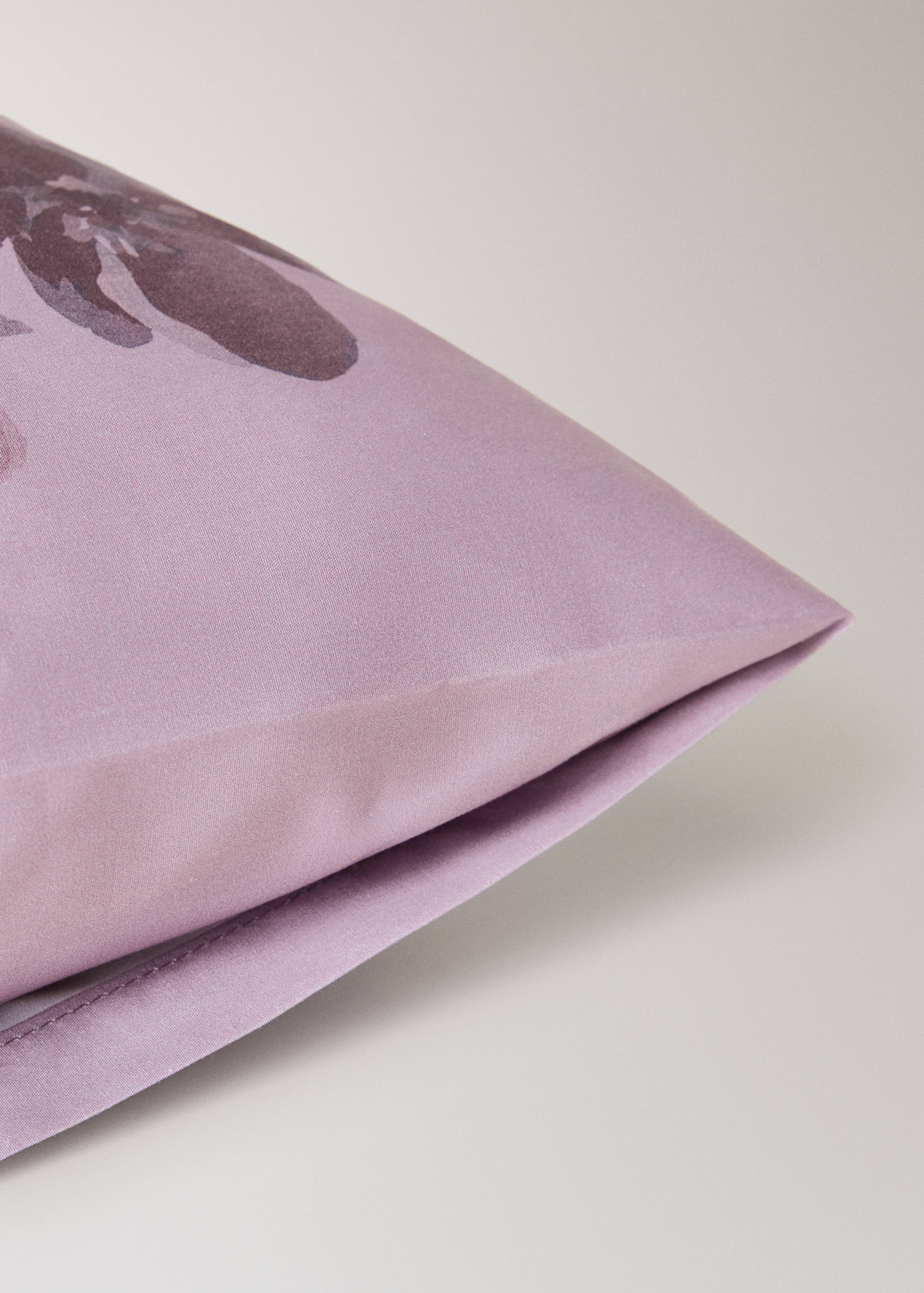 Lilac pillowcase with a dark floral print and stitched seam detail.