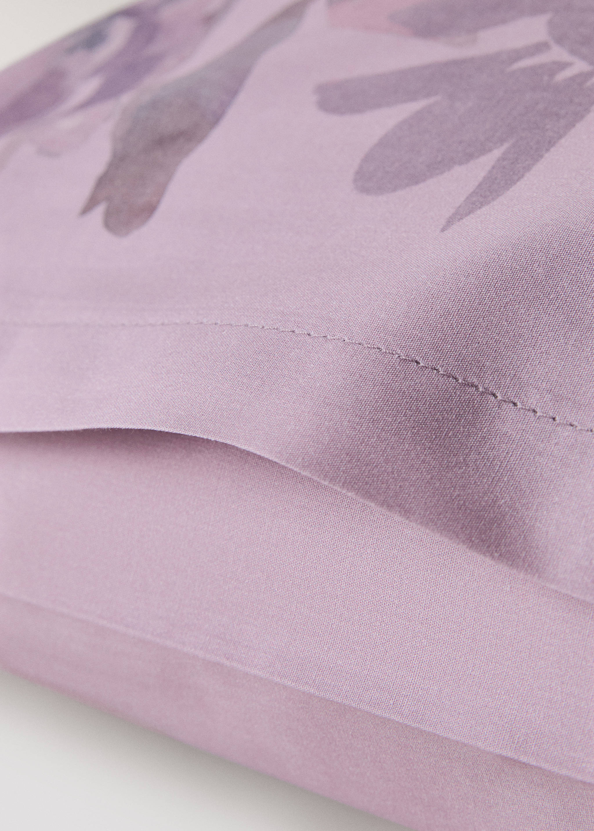 Lilac cotton pillowcase detail with abstract floral print.