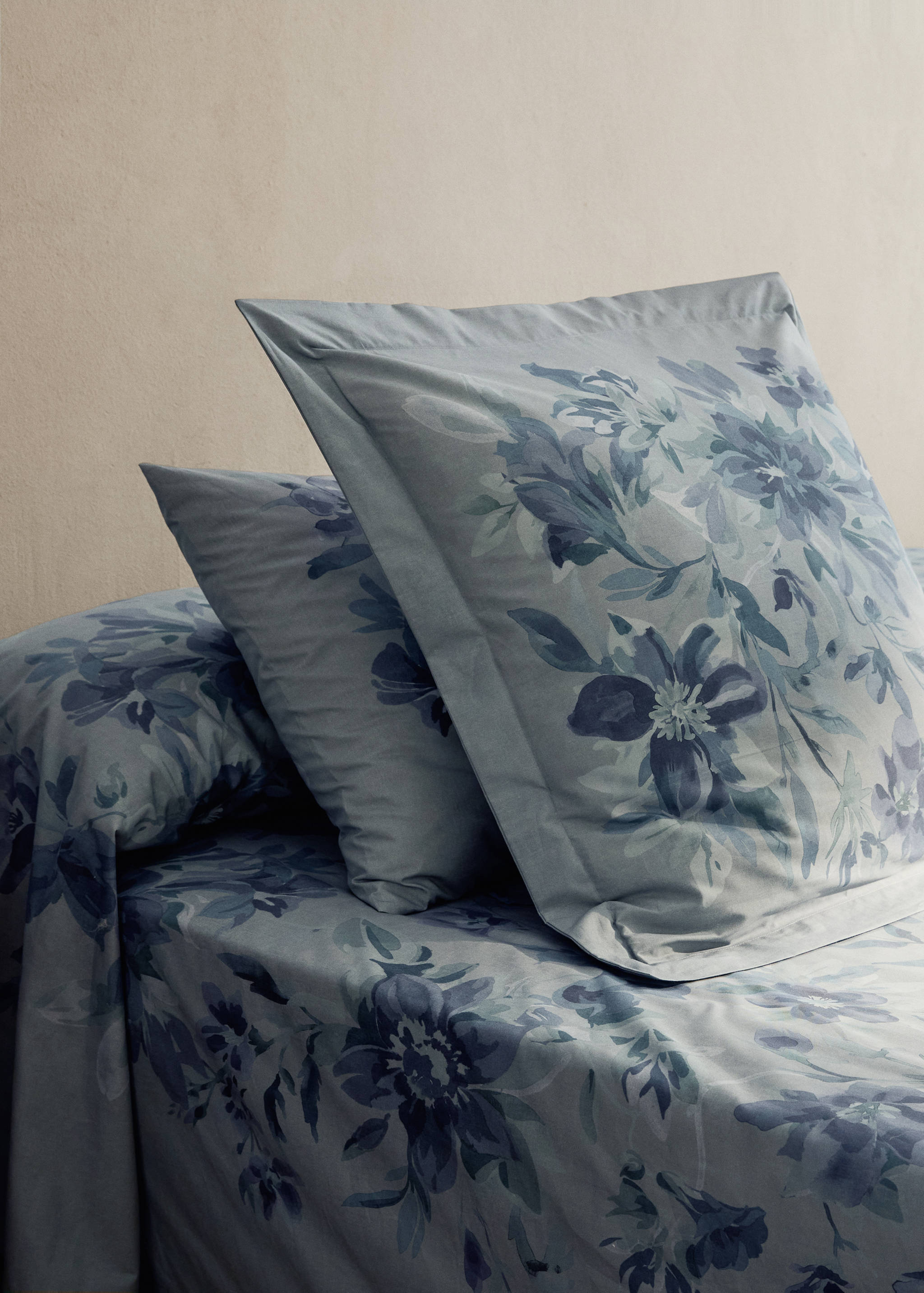 Blue floral pillowcase with watercolour design on matching bed linen.