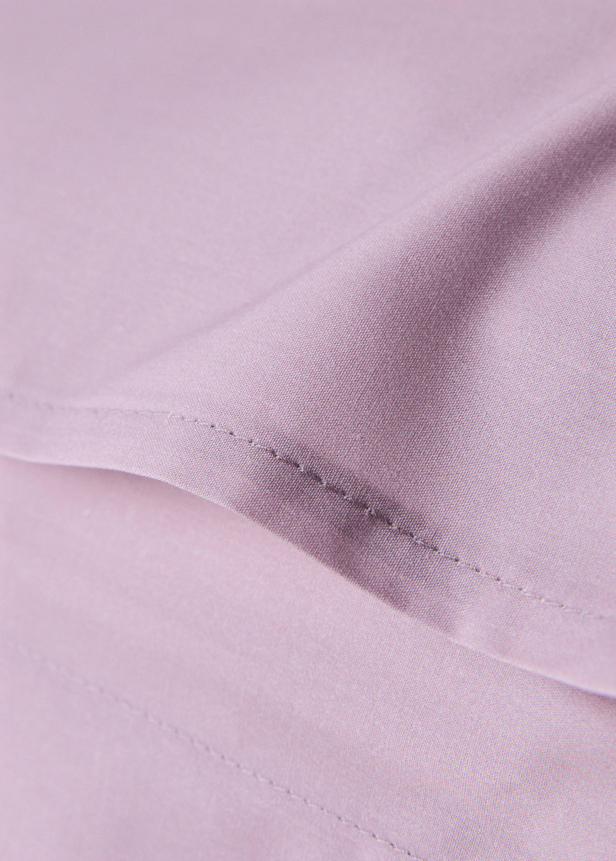 Mauve pillowcase fabric and stitched hem detail.