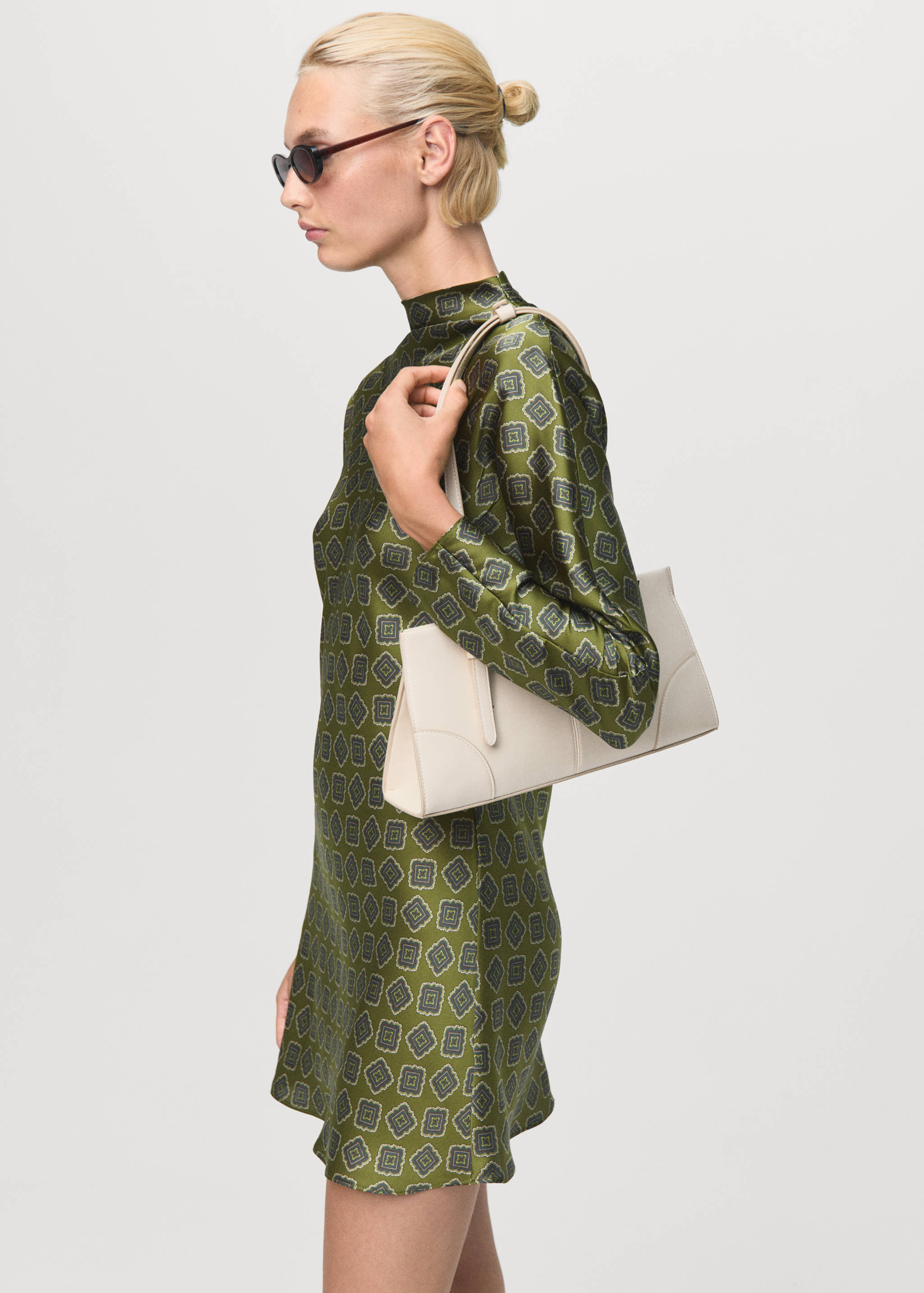 Green long-sleeved patterned dress with a high neckline.