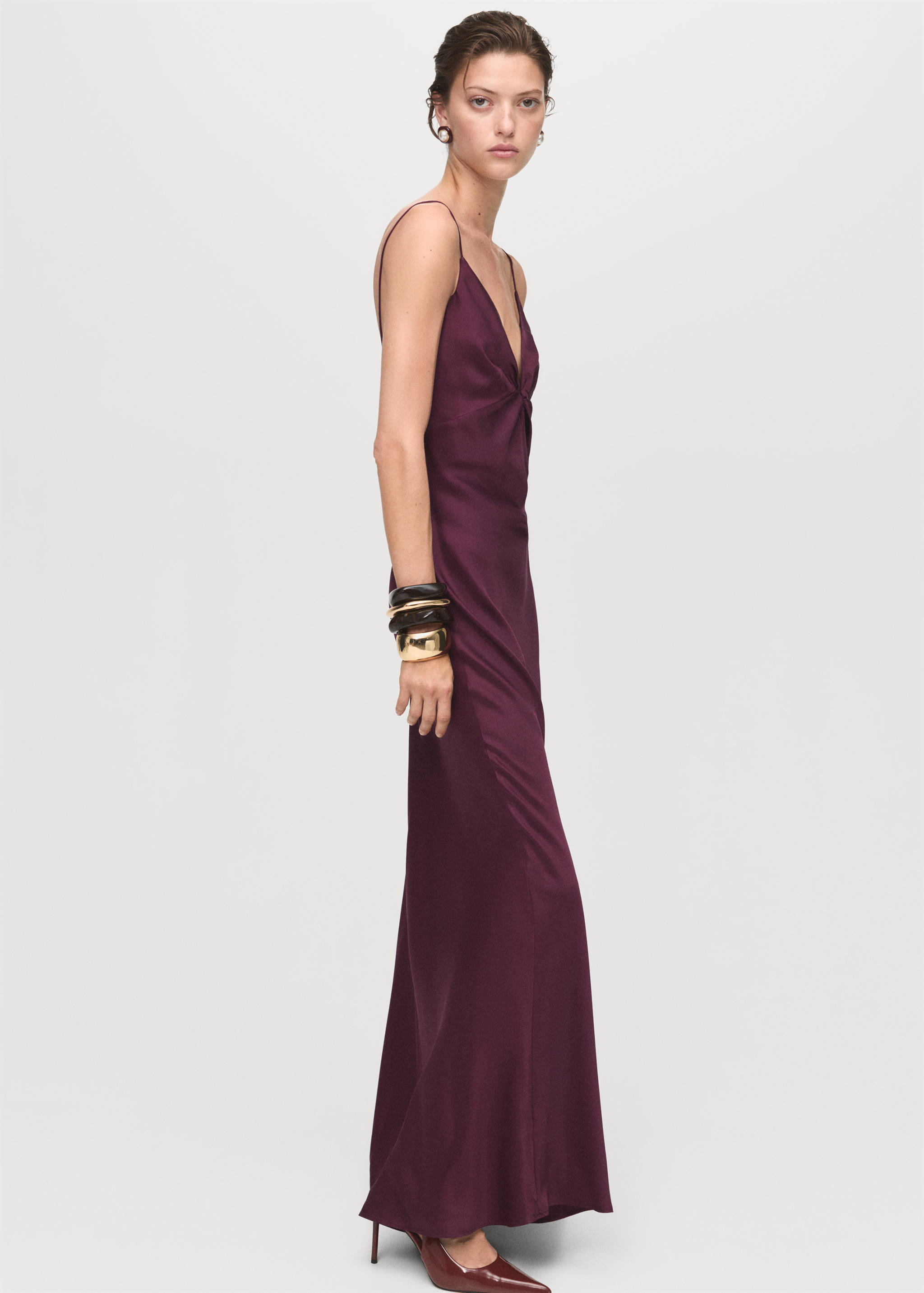 Dark purple slip dress with thin straps, deep V-neckline, and front knot detail.