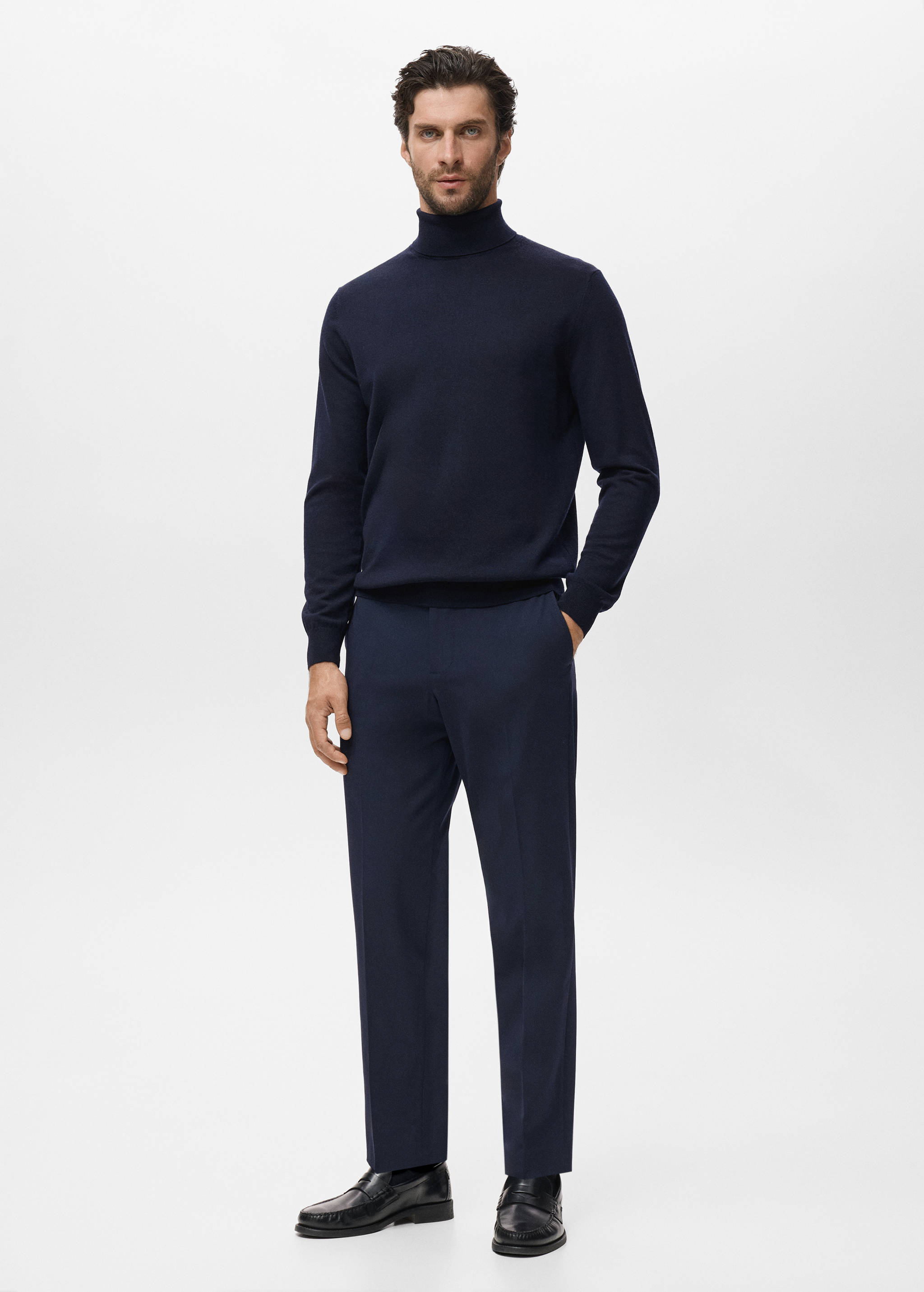 Navy blue turtleneck sweater in a classic knit, styled with matching trousers.