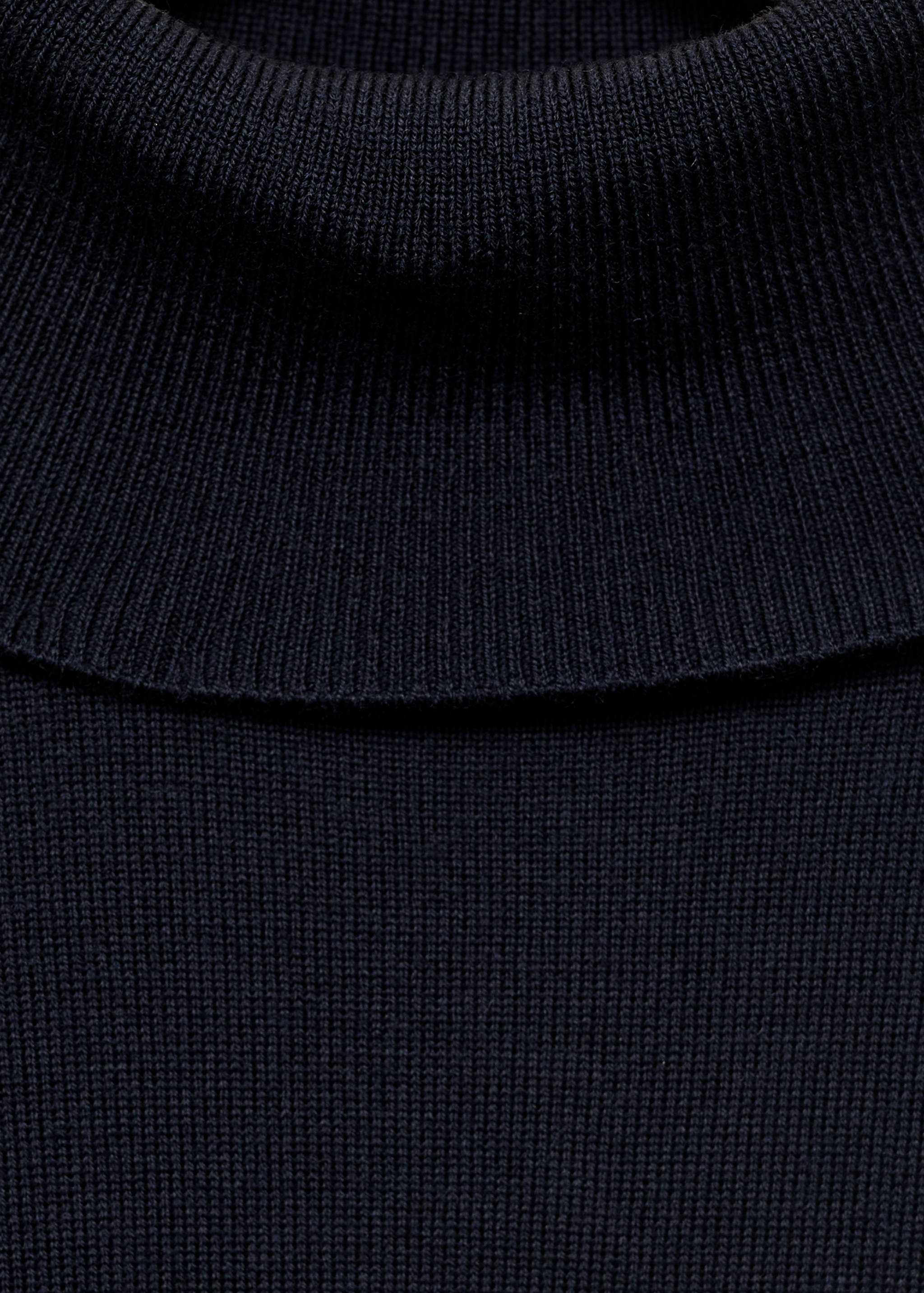 Dark blue knitted roll-neck jersey close-up.