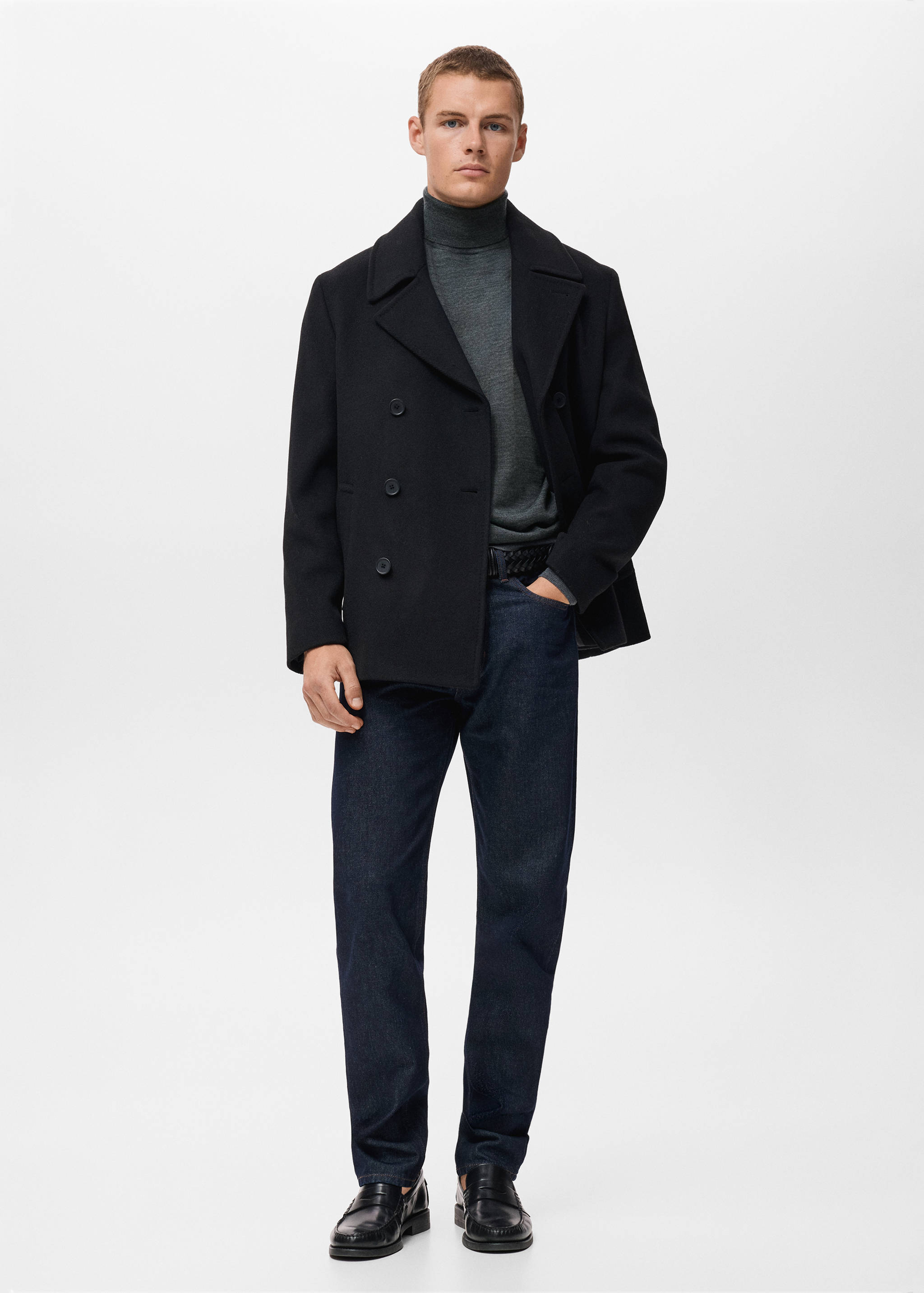 Grey turtleneck jersey worn with a black peacoat and dark blue trousers