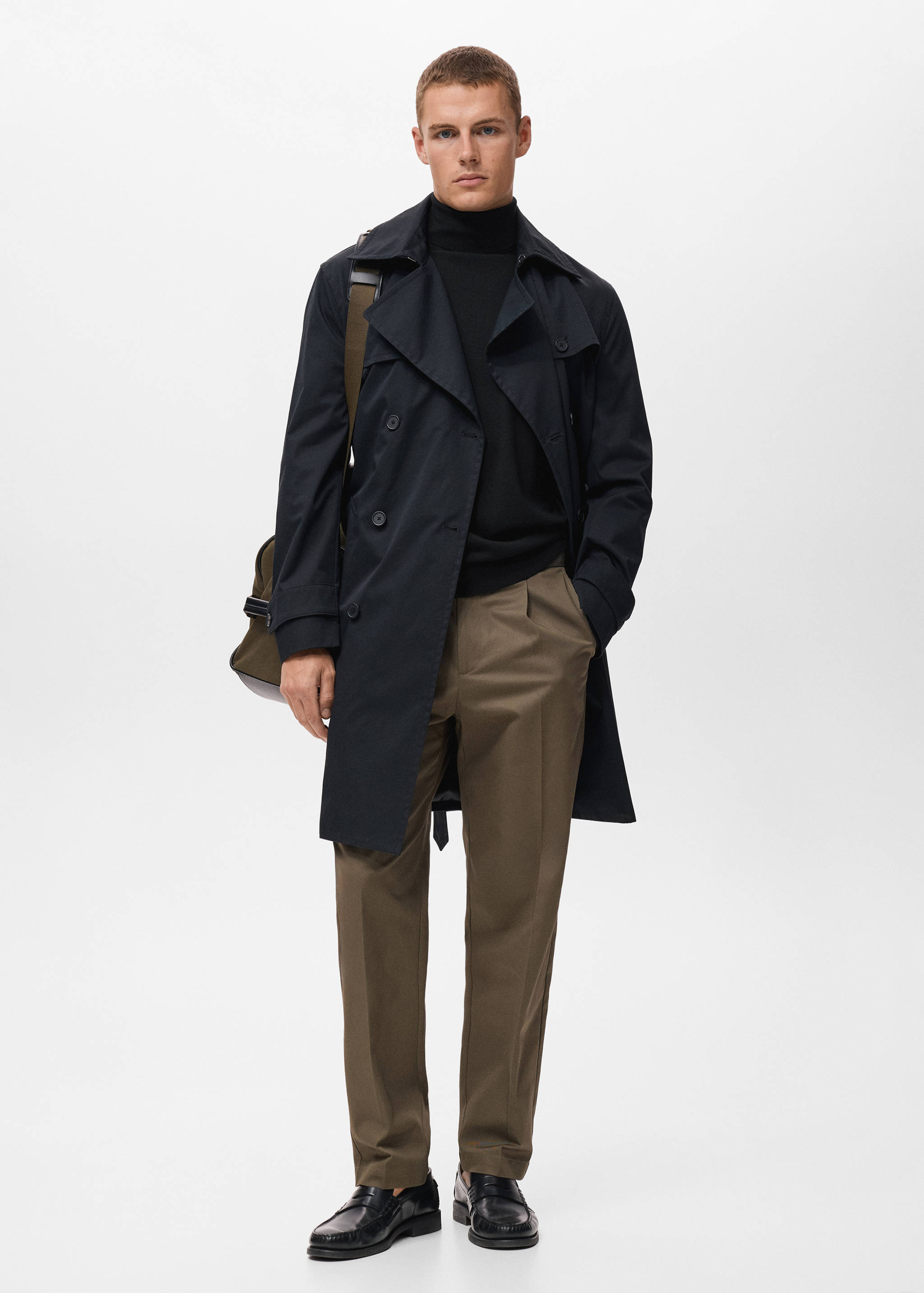 Black turtleneck jersey styled with a navy trench coat and trousers.
