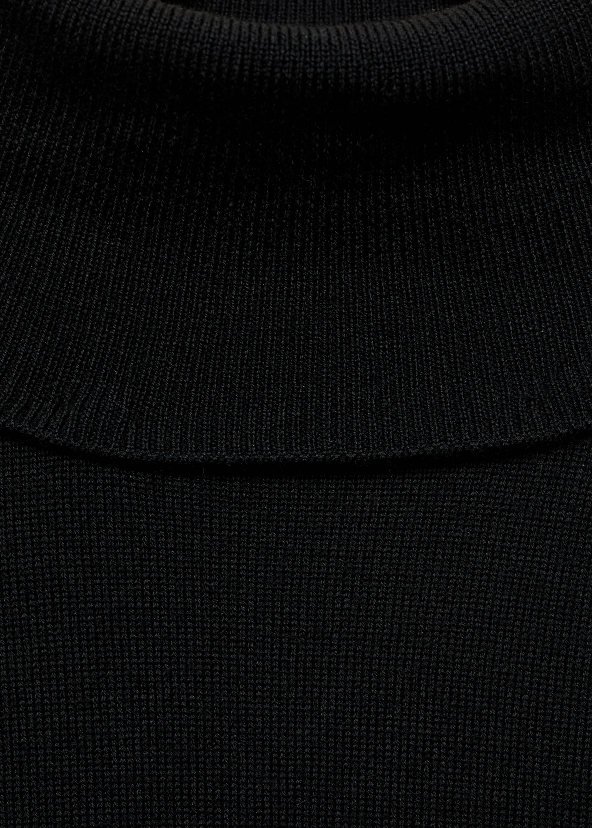 Close-up of a black knitted jersey featuring a ribbed turtleneck.