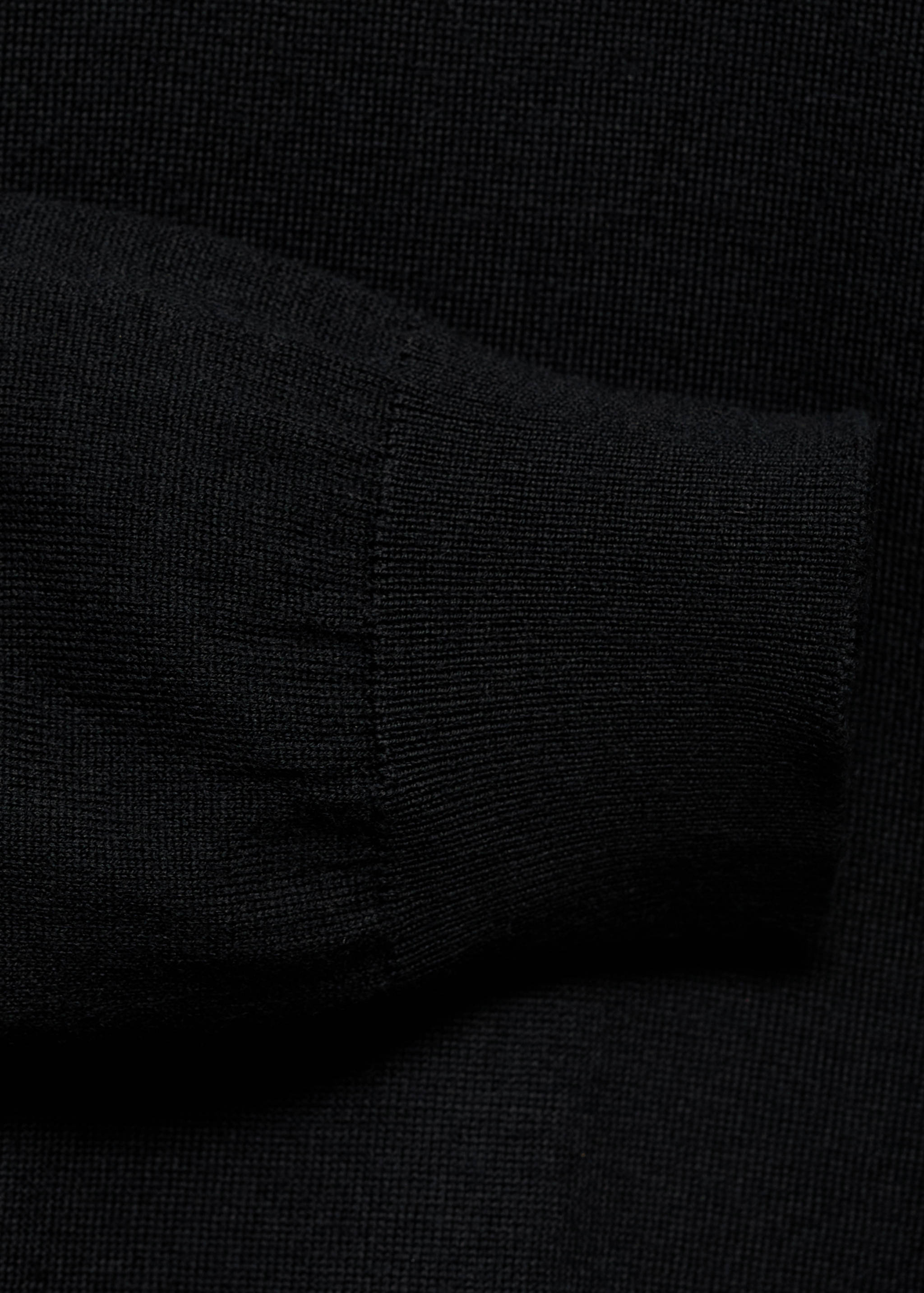 Close-up of the black jersey fabric and ribbed cuff.