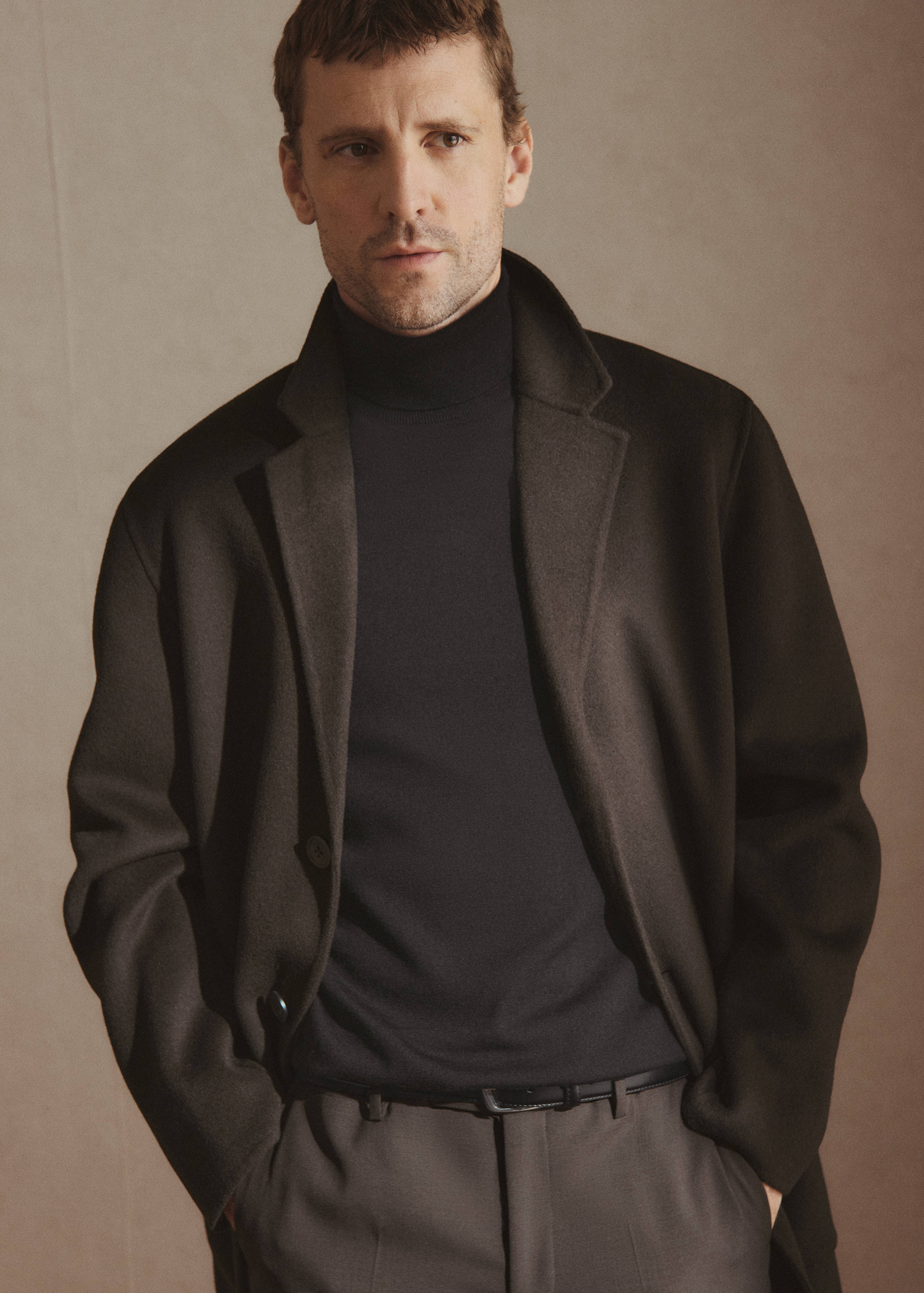 Black turtleneck jersey with a fitted silhouette and high roll collar.