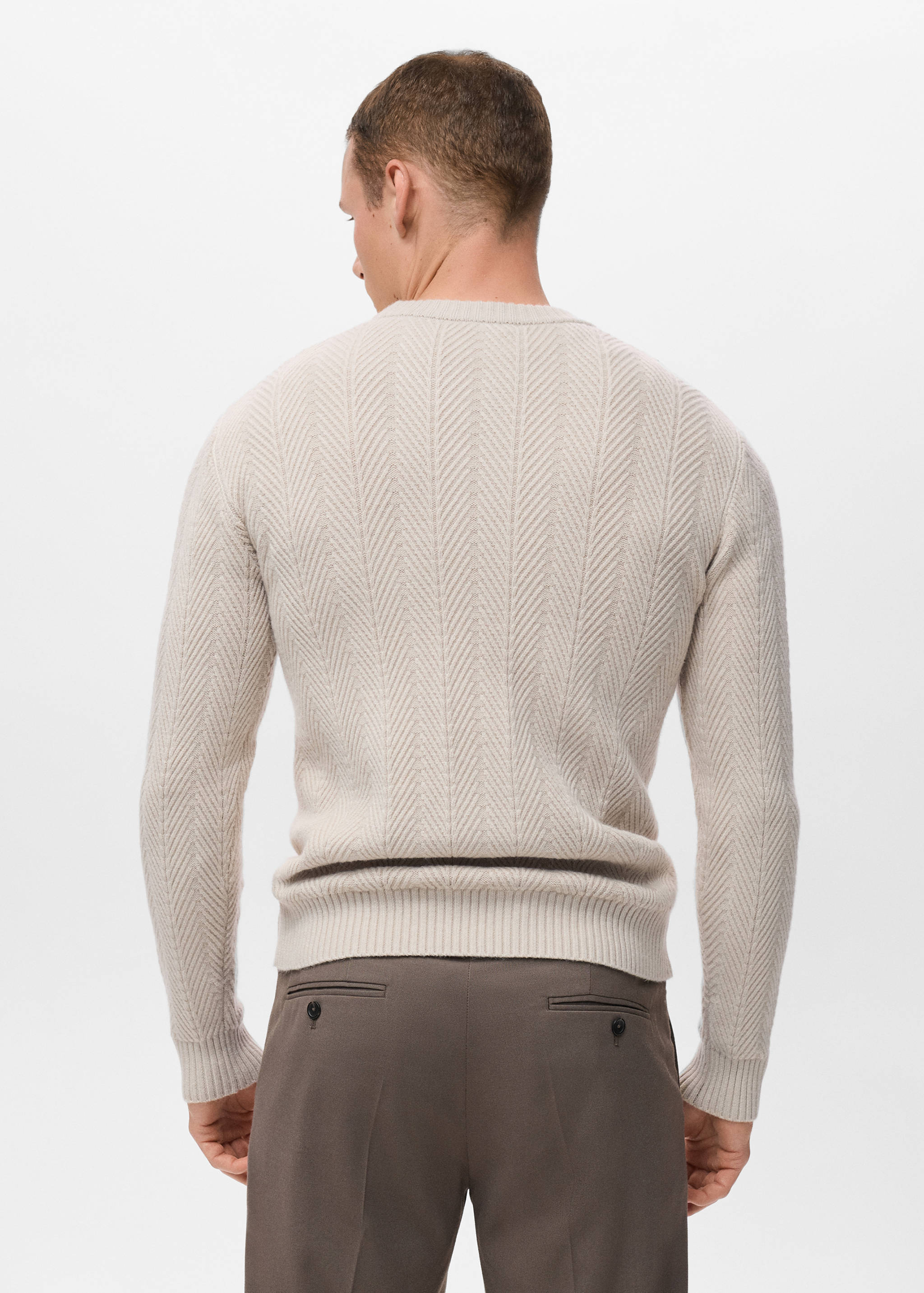 Back view of a cream knitted jumper with a chevron pattern.