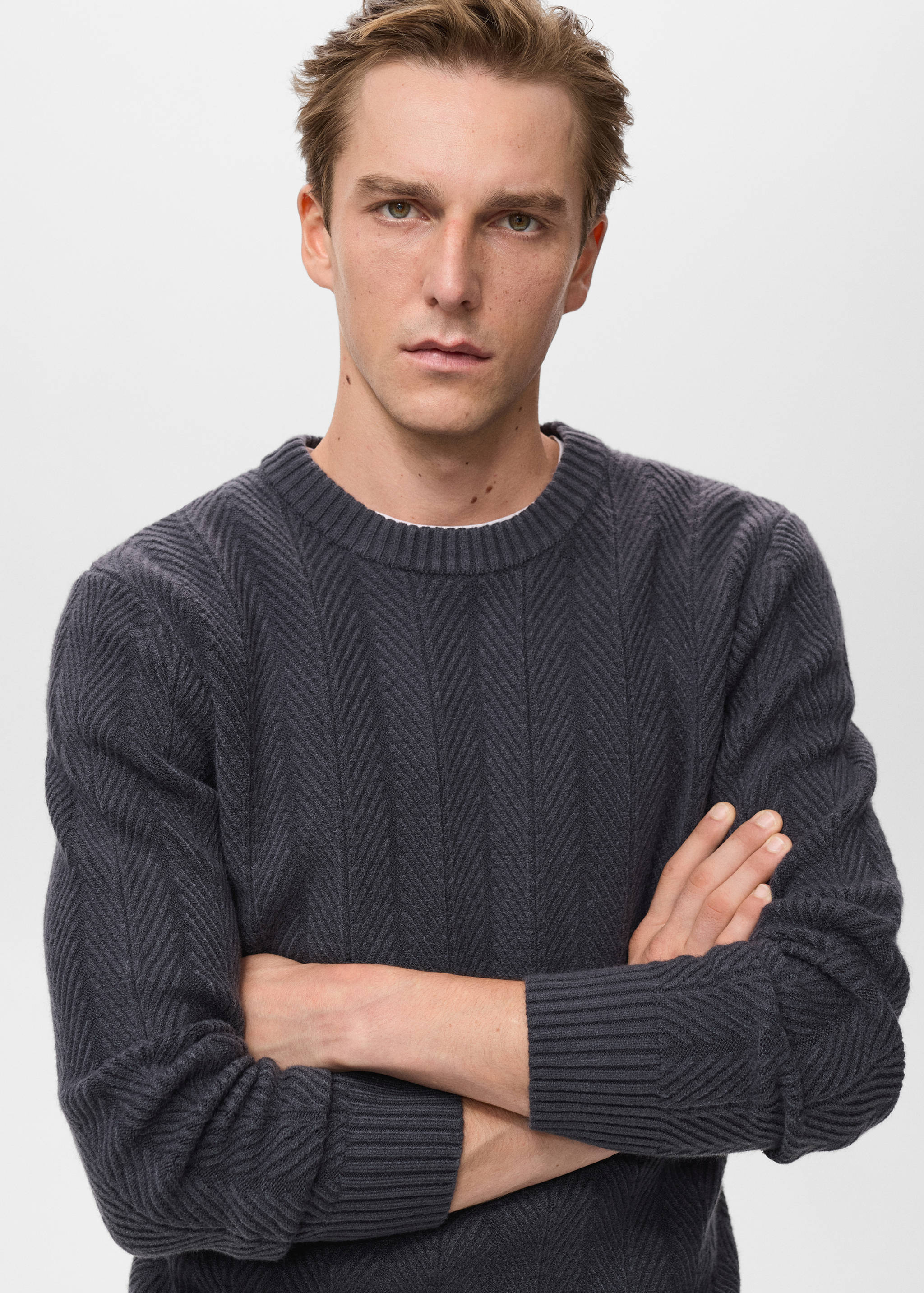 Dark grey knitted jumper with round neck and chevron pattern.
