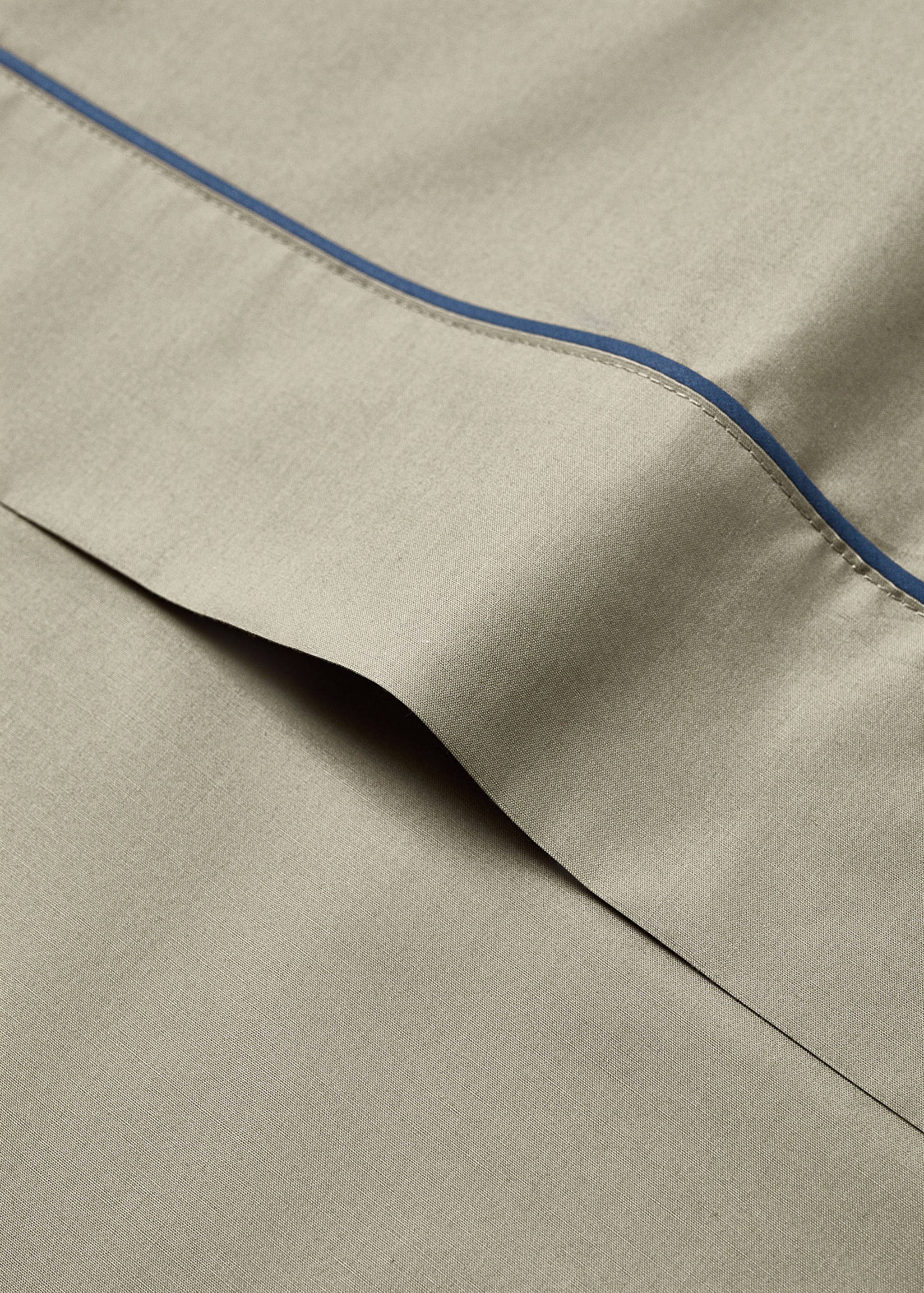 Beige flat sheet detail with contrast blue piping.