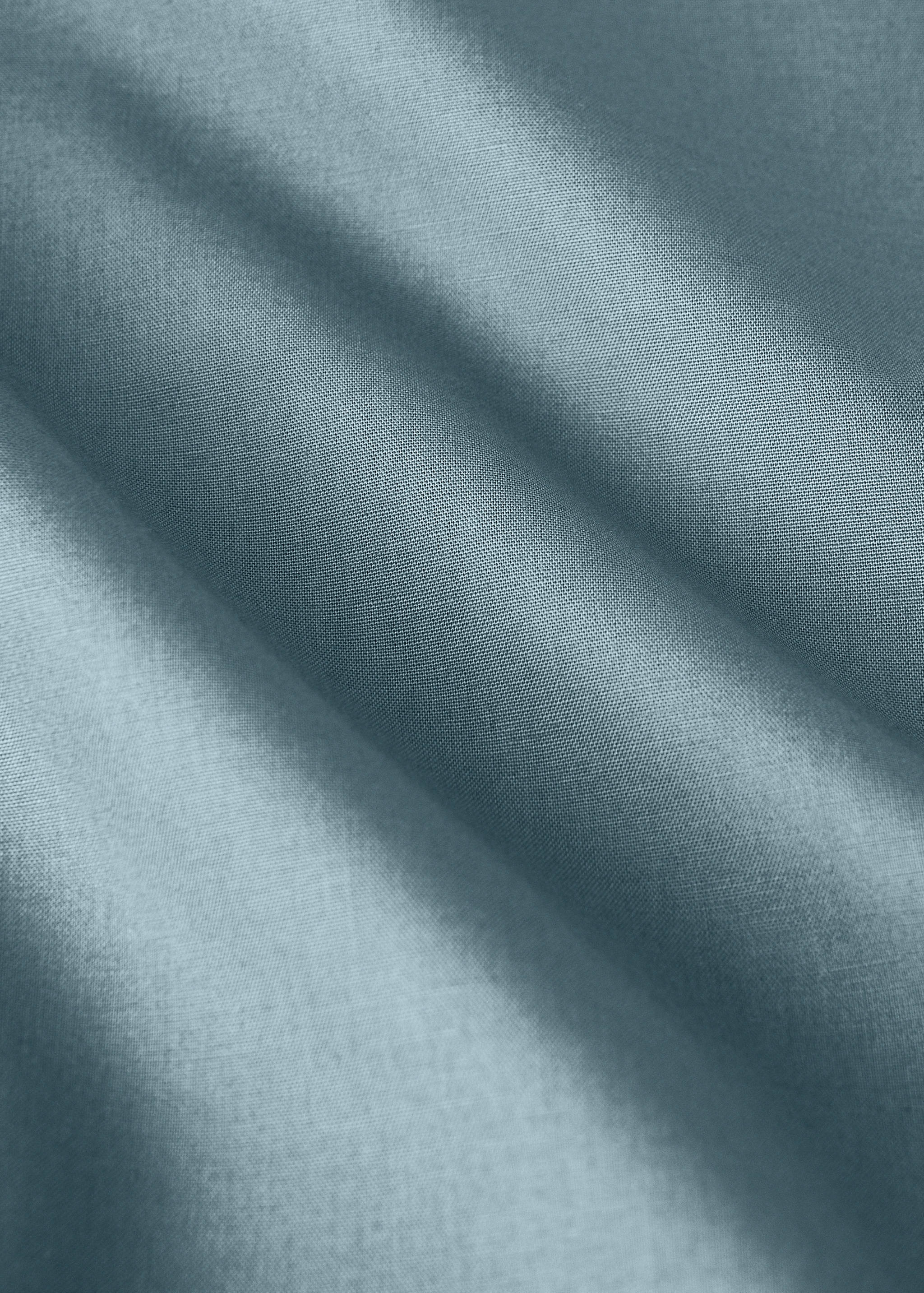 Close-up of a muted grey-blue flat sheet showing fabric texture.