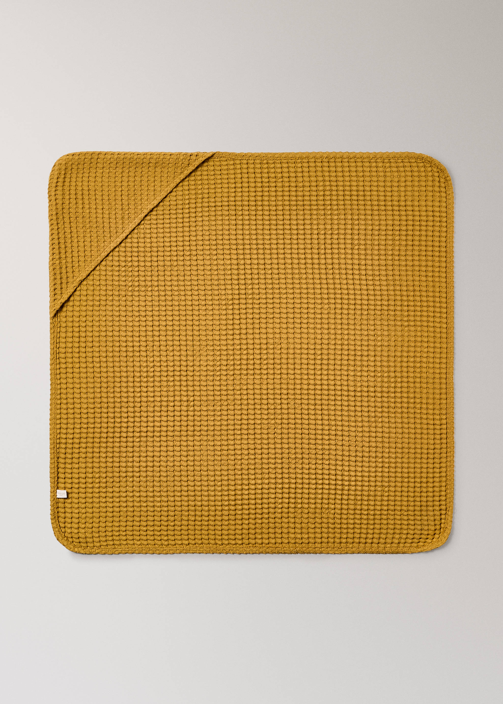 Mustard yellow waffle-texture hooded towel laid flat.
