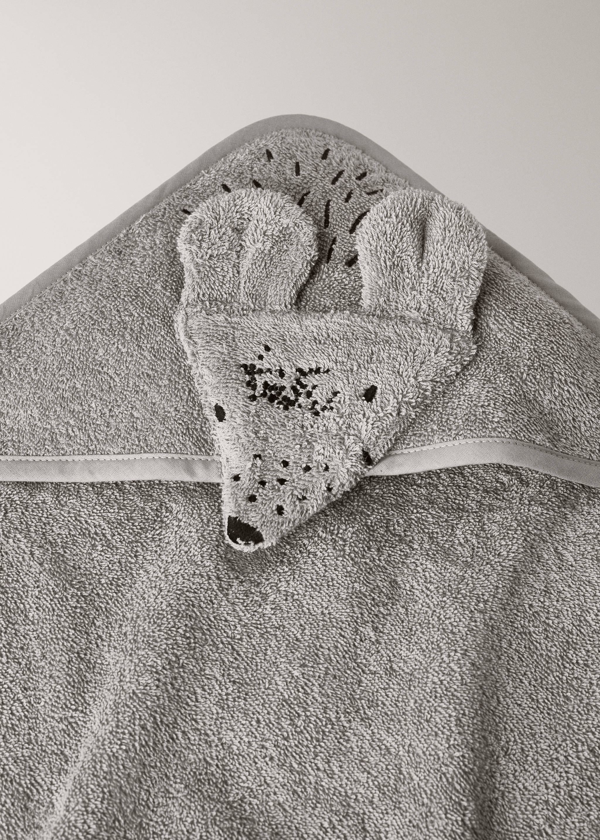 Grey hooded baby towel in terry cloth with an embroidered animal face detail.