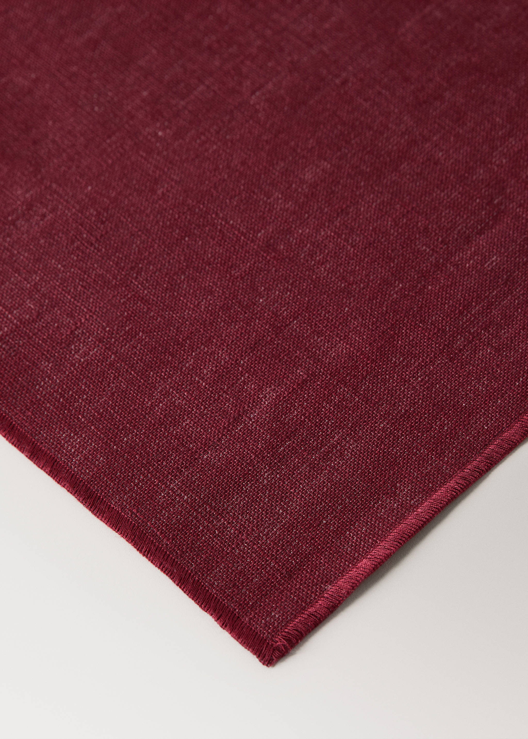 Dark red placemat with a textured weave and stitched border.