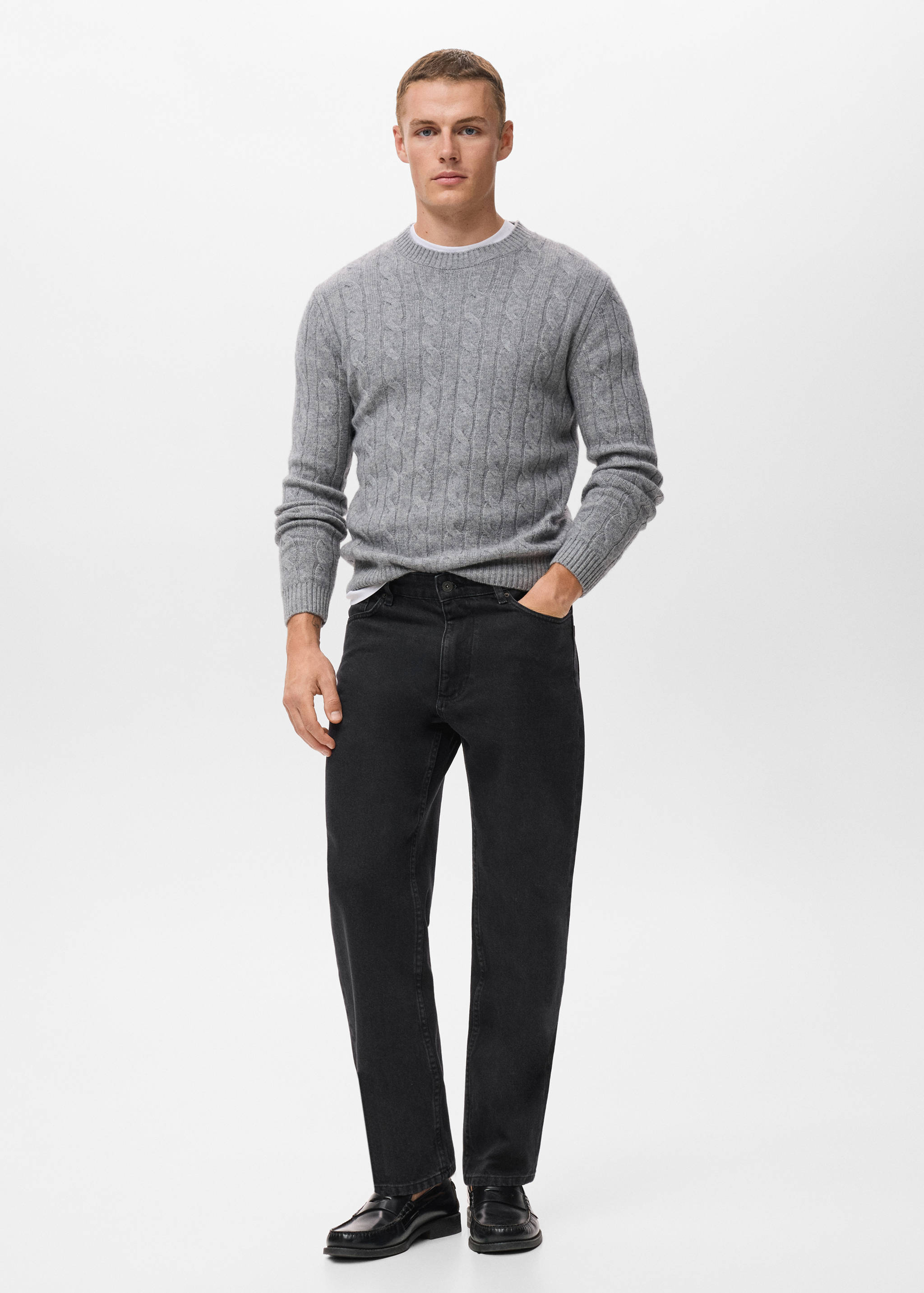 Black straight-leg denim trousers worn with a grey cable-knit sweater.