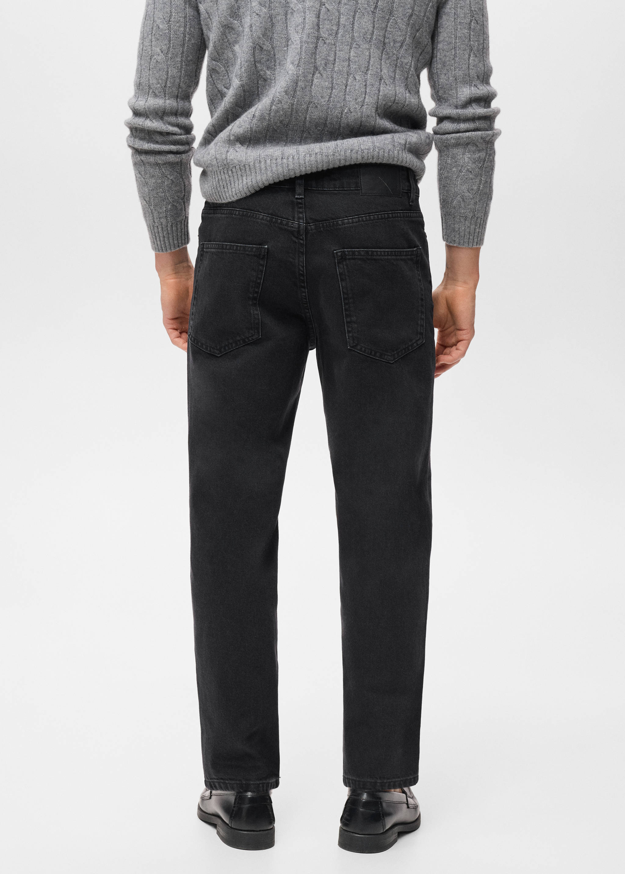 Dark grey denim trousers, back view, worn with a grey sweater.