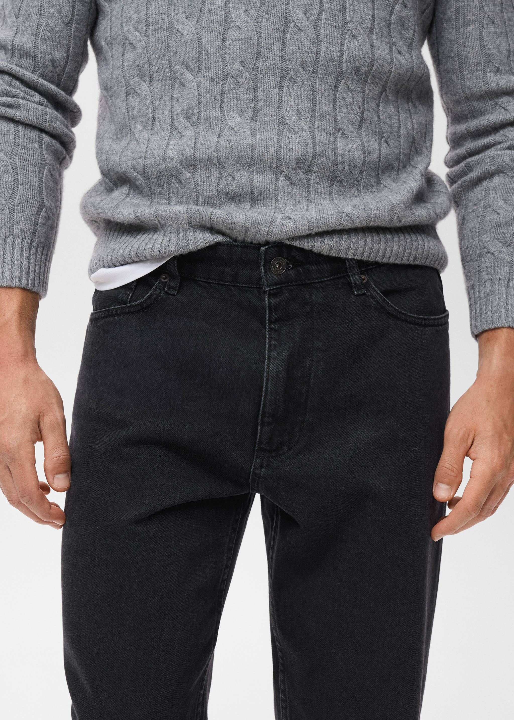 Black denim trousers with a mid-rise waist and button fastening.