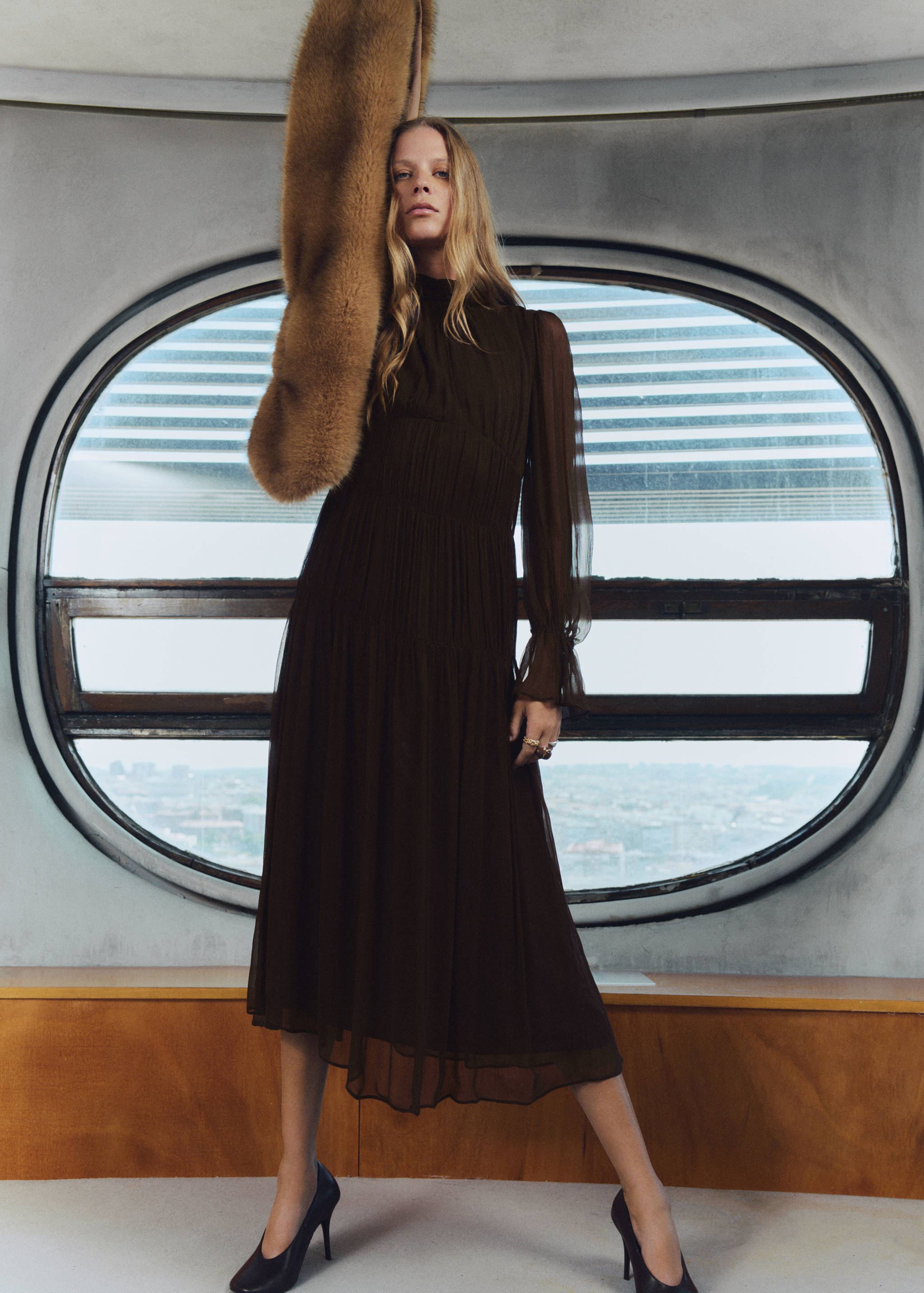 Dark brown midi dress with a high neck, sheer long sleeves, and a smocked bodice.