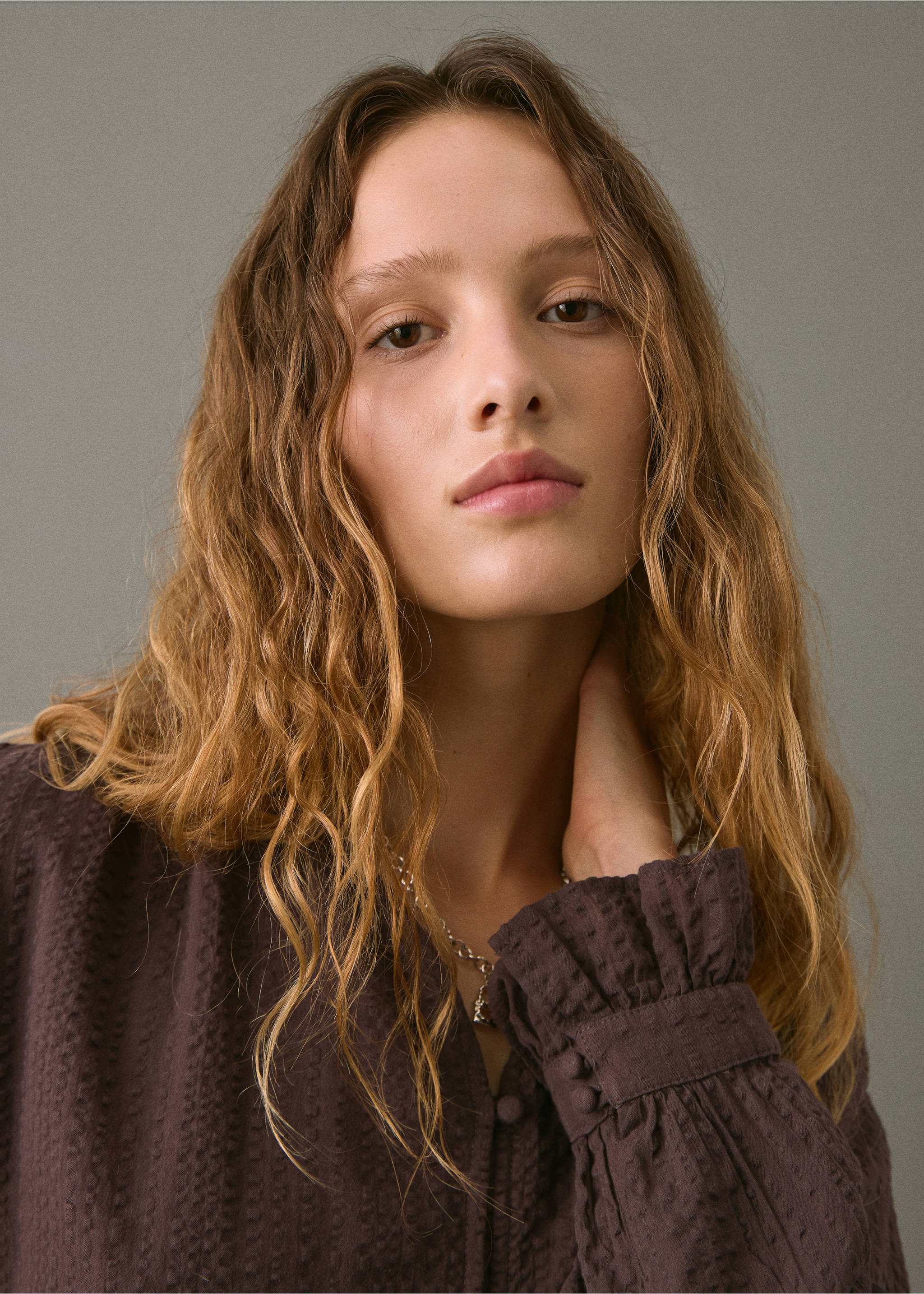 Dark brown textured blouse with long sleeves and buttoned cuffs in a close-up view., Brown. Ref: 17026337-00.