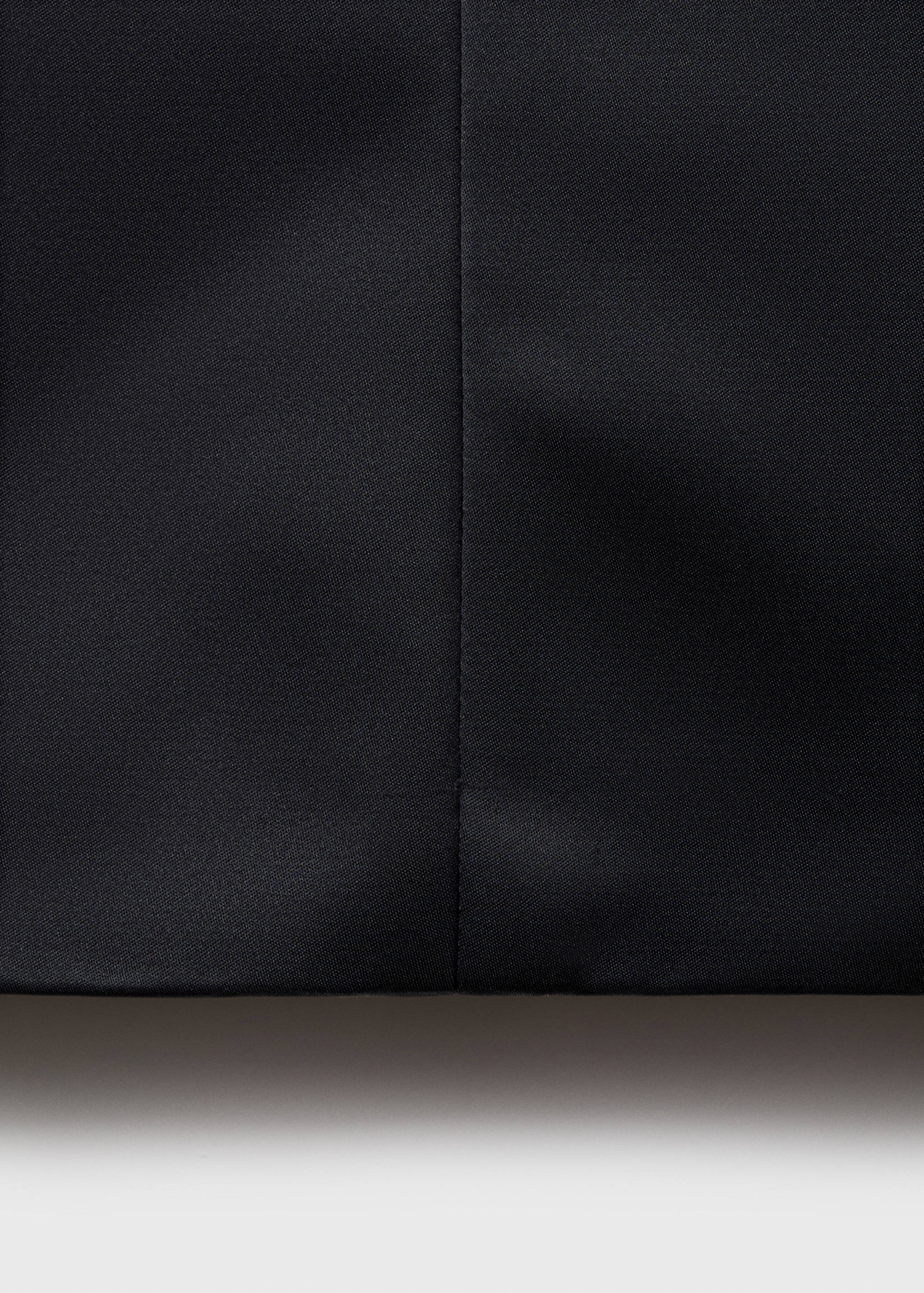 Close-up of the black dress fabric and seam detail.