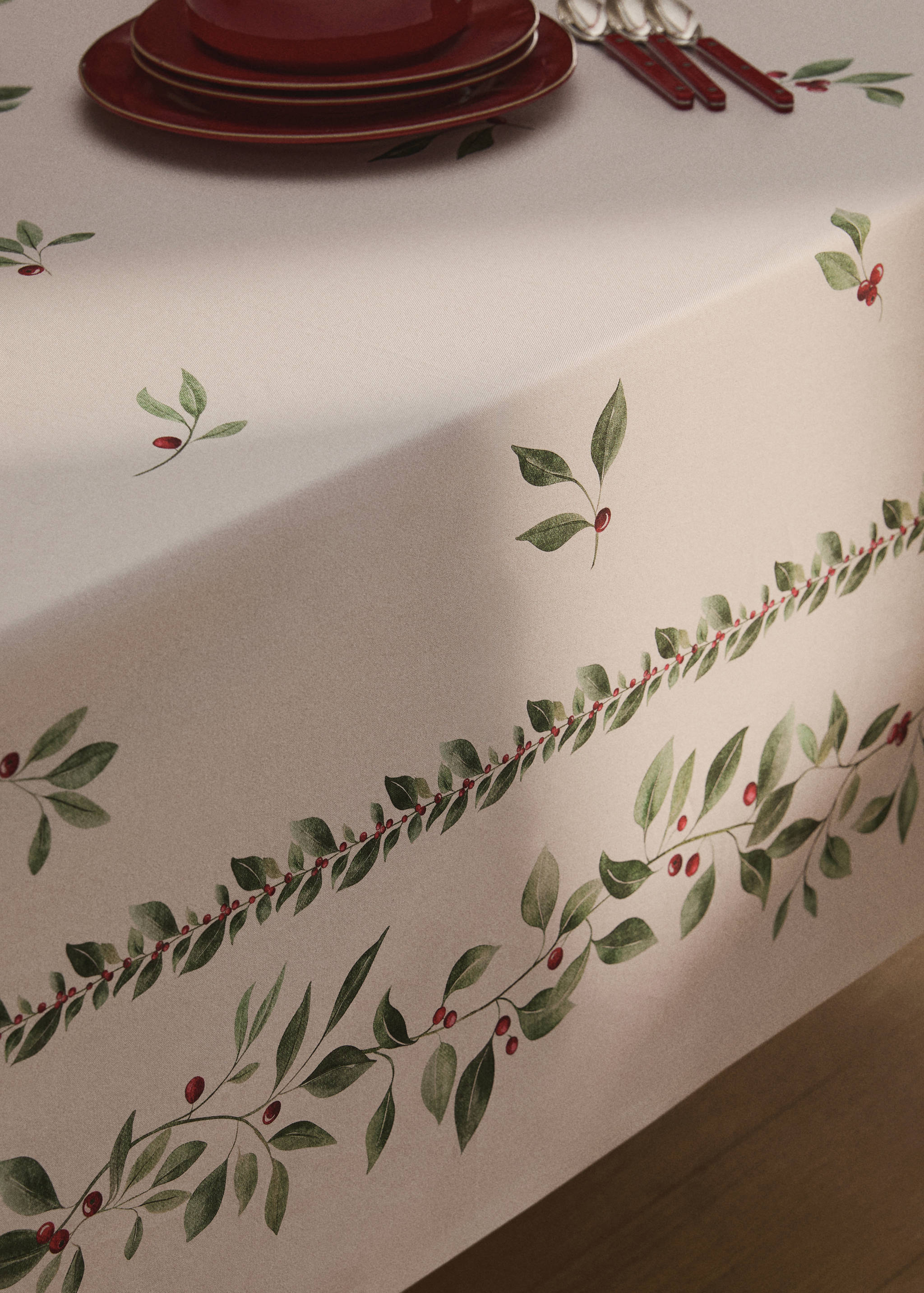 Cream tablecloth with a botanical green leaf and red berry print.