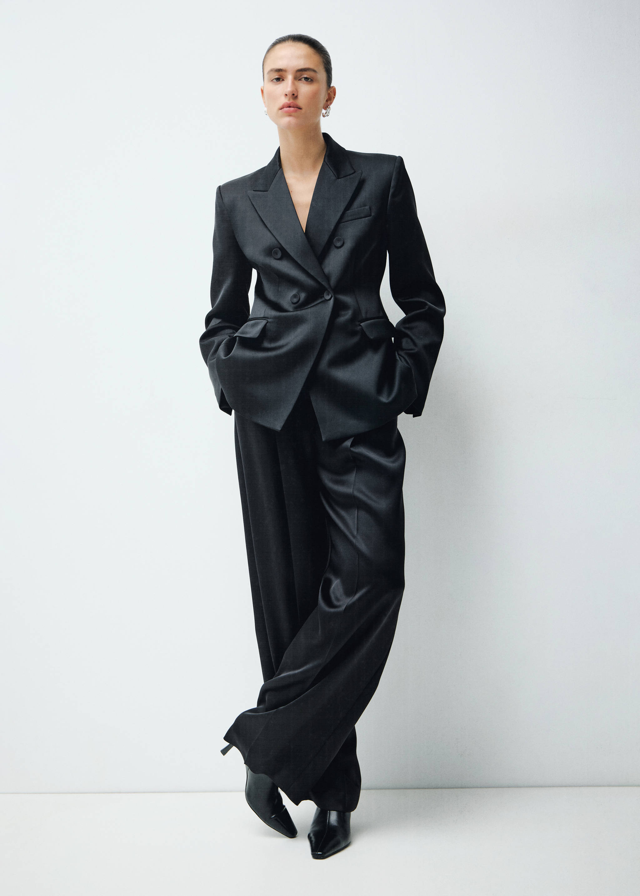 Black double-breasted satin blazer with matching wide-leg trousers.